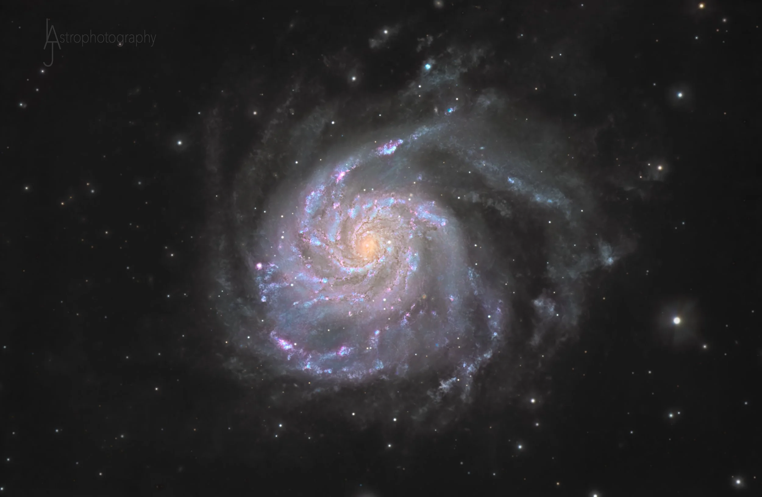 Deep space image of a spiral galaxy with bright central core and colorful arms, surrounded by numerous distant stars.