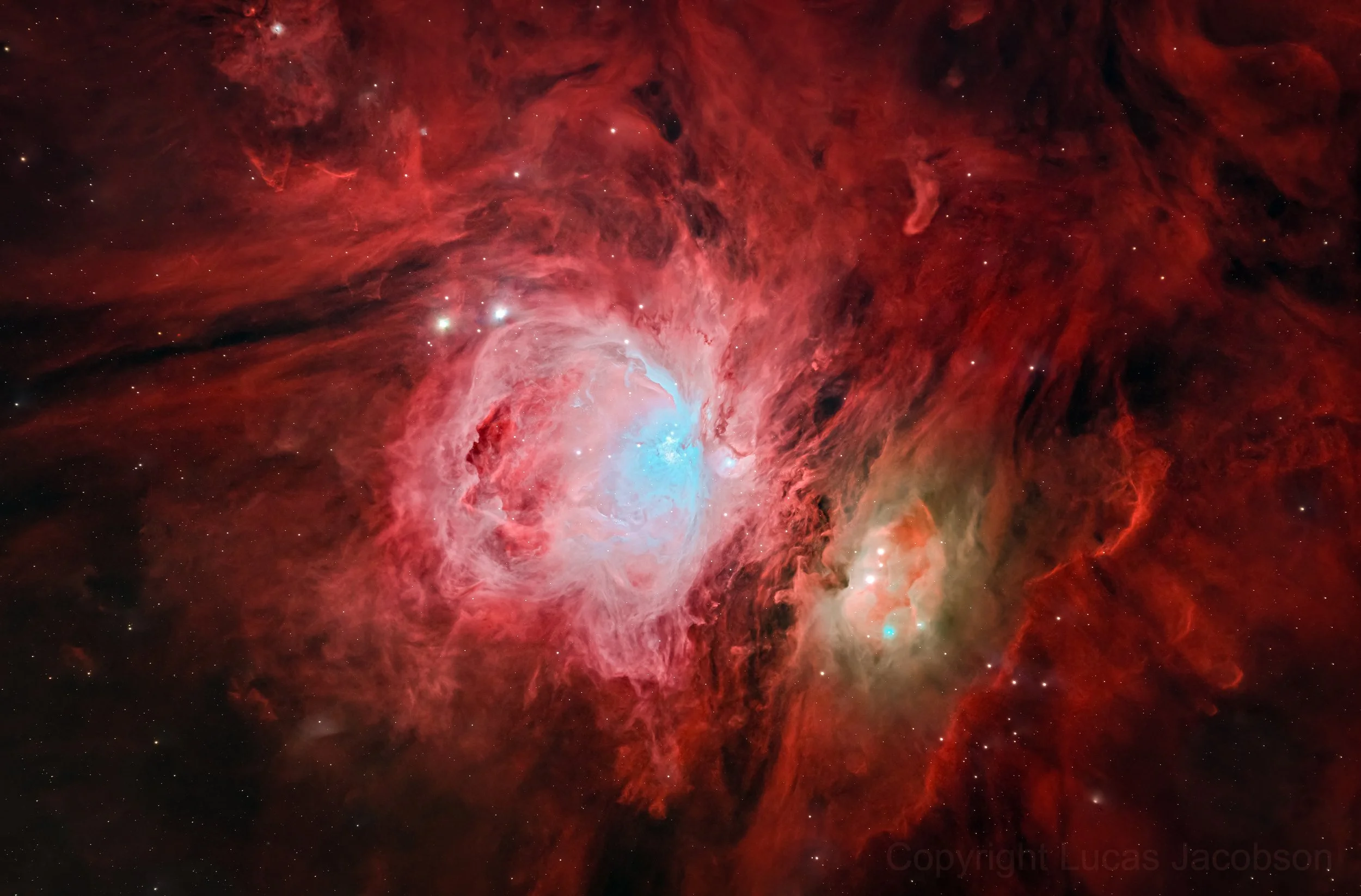 A detailed image of a red and pink nebula with bright stars scattered throughout.