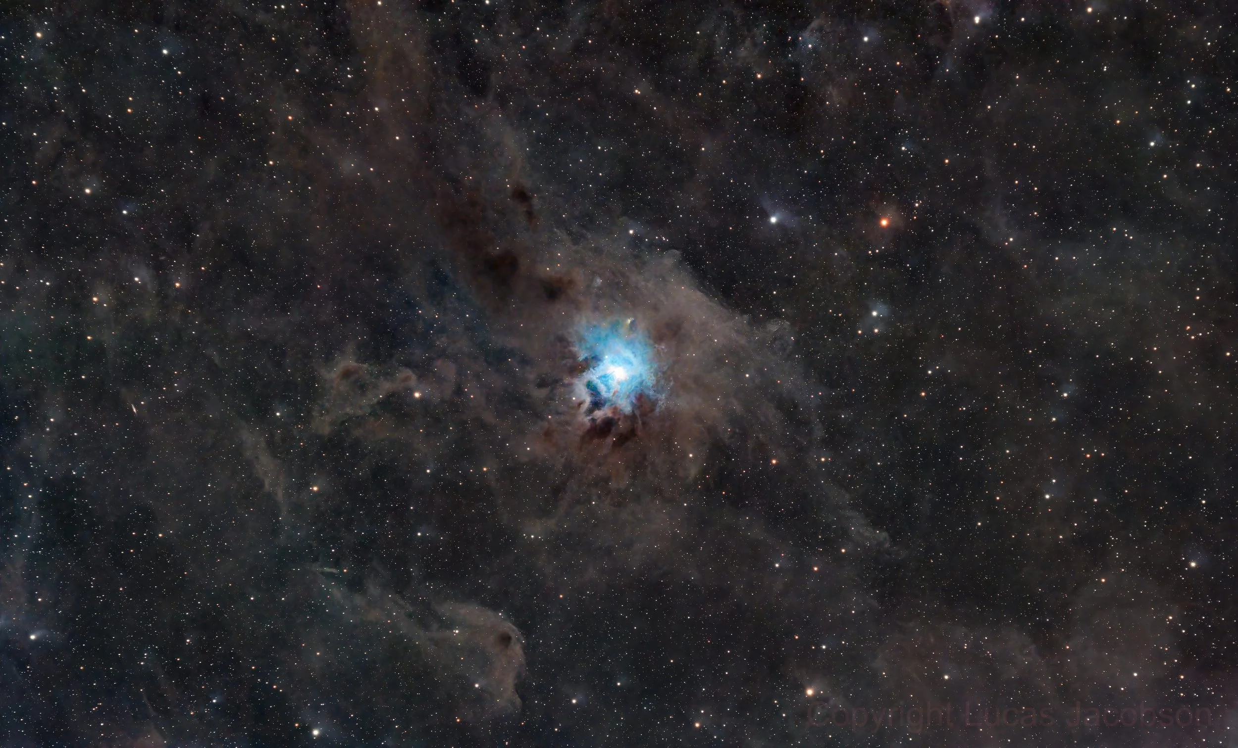A detailed view of outer space featuring numerous stars, nebulae, and cosmic dust clouds, centered around a bright blue and white nebula.