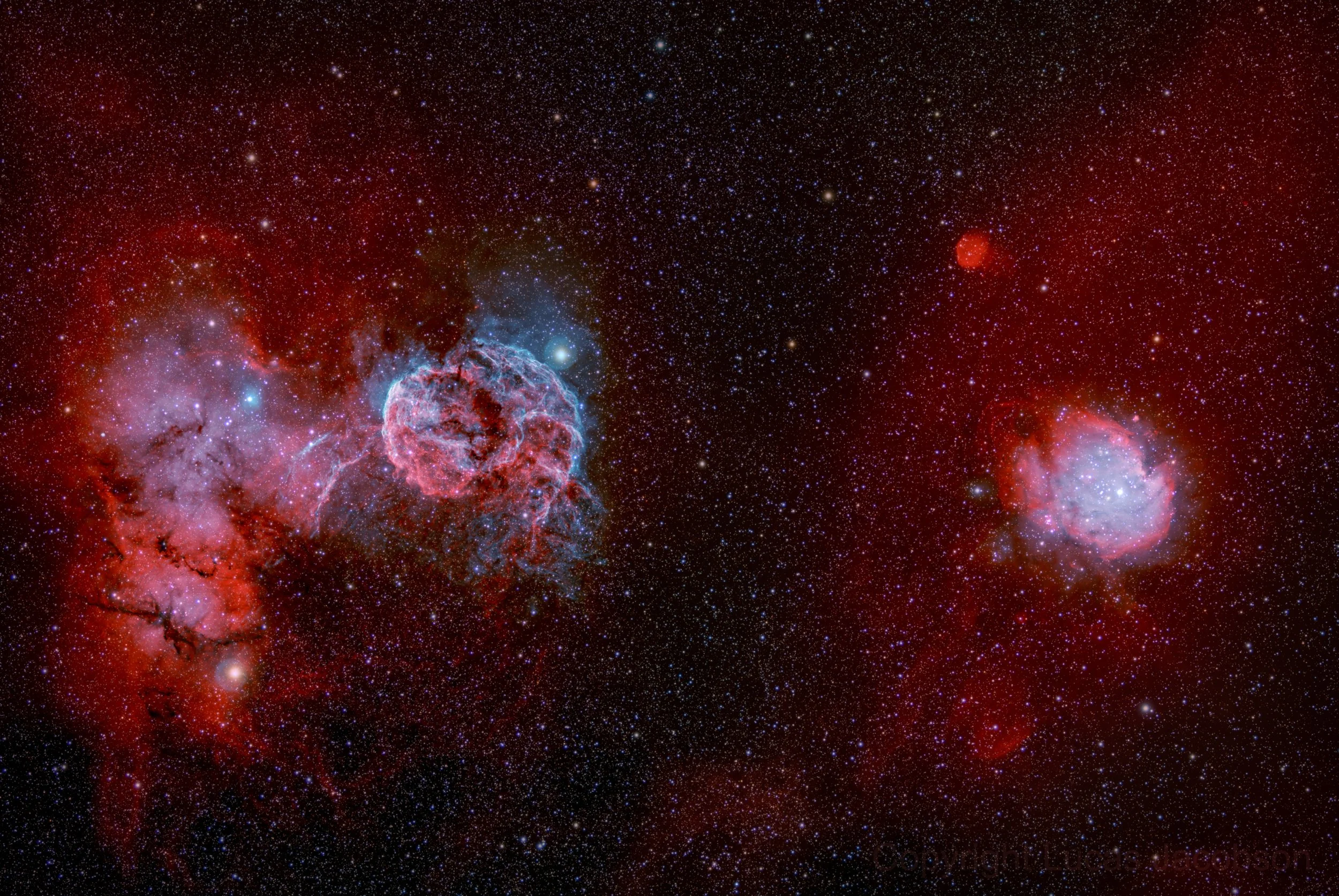 A detailed image of outer space featuring numerous stars and vibrant nebulae with reddish and blue hues.