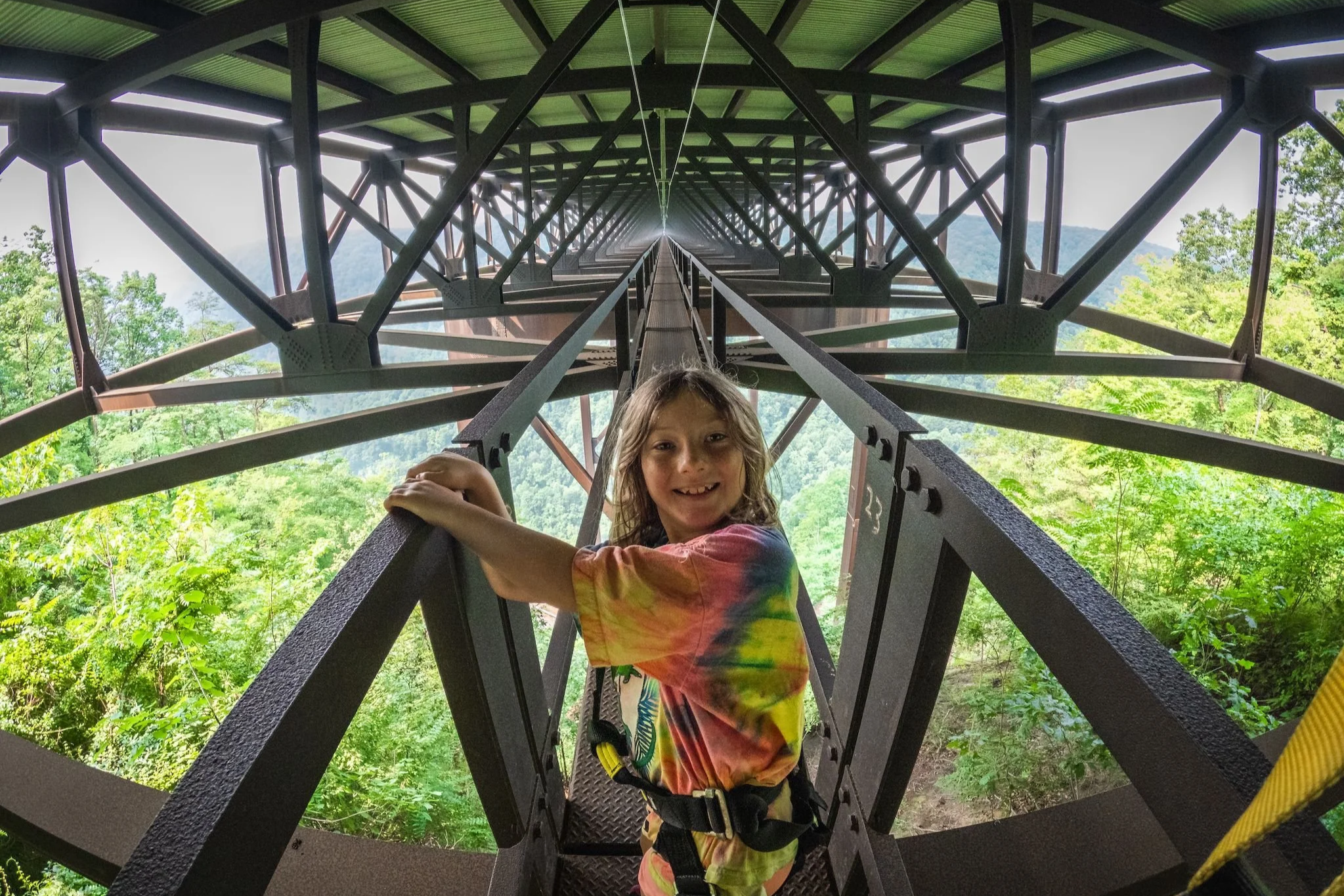 Young girl walking under a metal bridge on the Bridge Walk