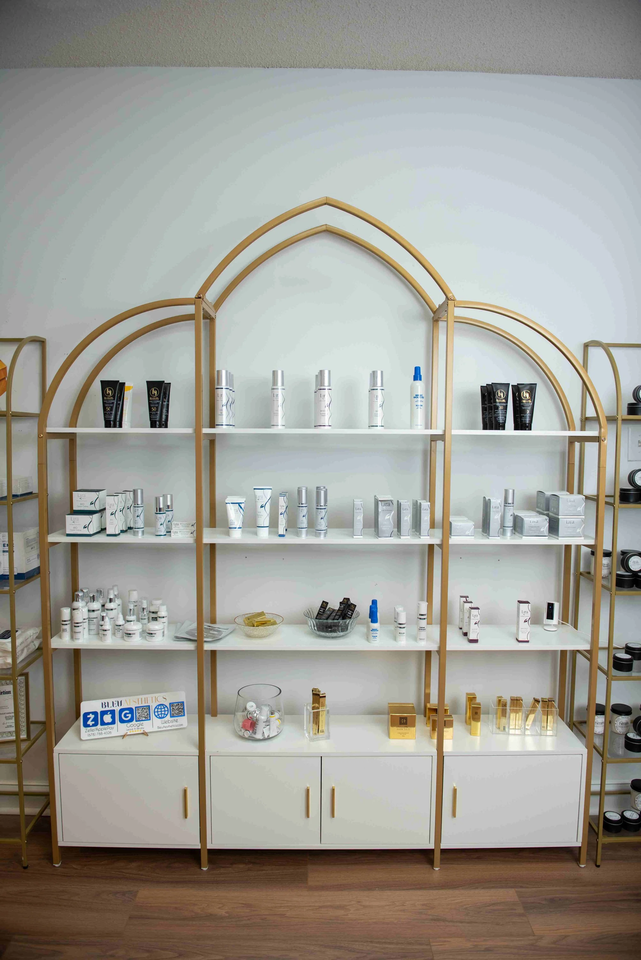 Display shelf with skincare and beauty products arranged on multiple levels, in a retail or cosmetic store.