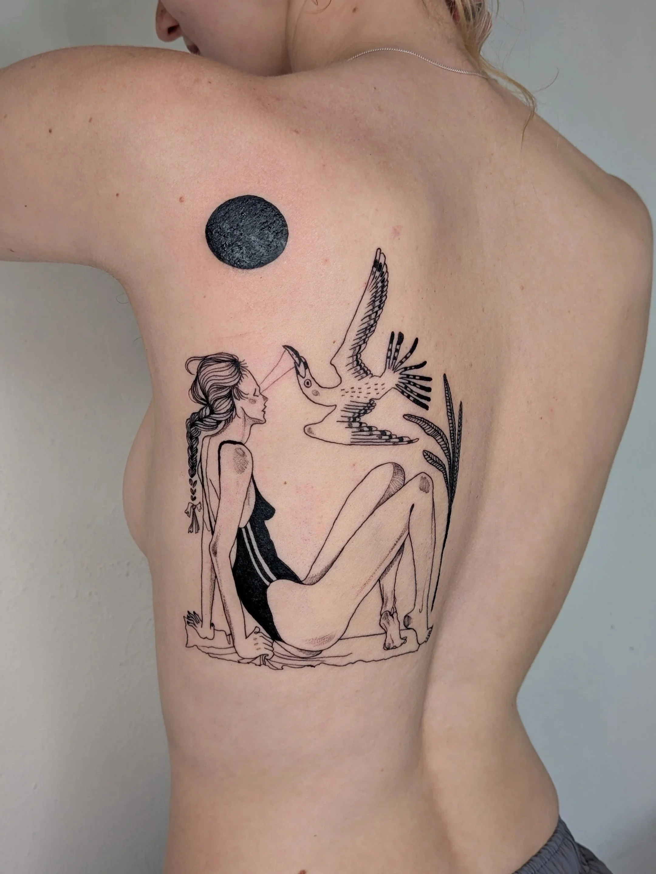 A tattoo on a person's side depicting a line drawing of a woman with long, flowing hair, sitting with her legs bent, reaching up towards a flying bird and a black circle above her shoulder.