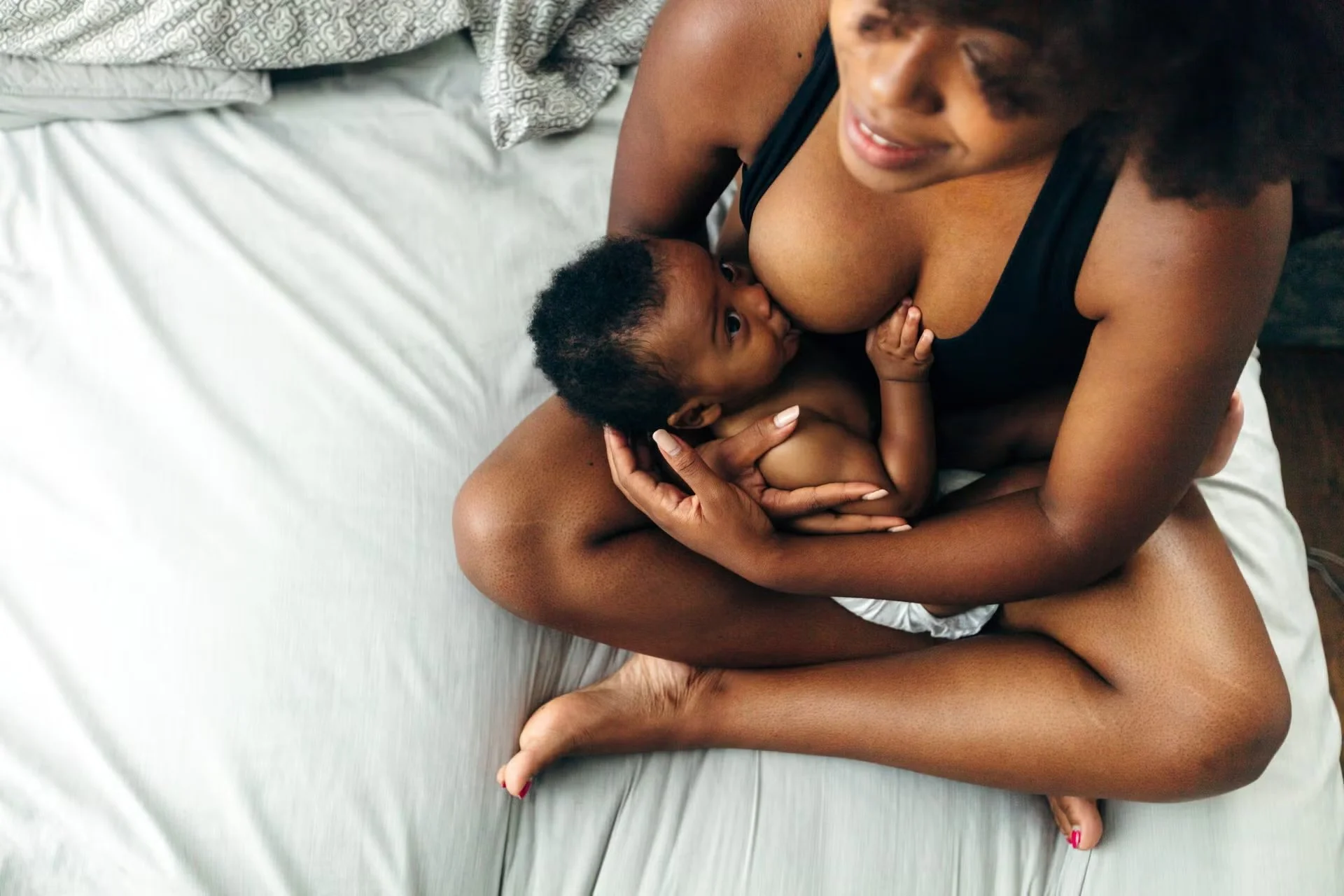 Black mother breast feeding newborn child