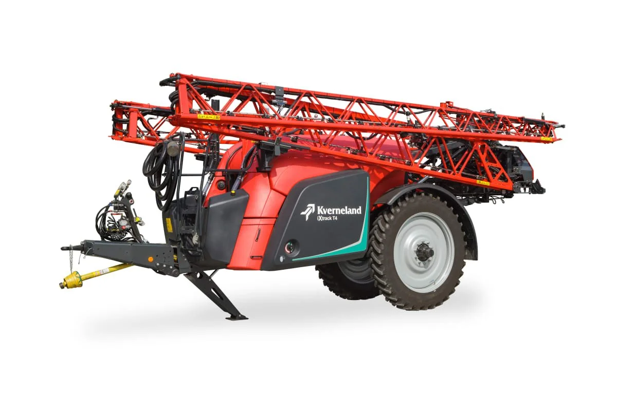 Un pulvérisateur agricole rouge et noir avec une grande trémie et un rampe extensible, utilisé pour la pulvérisation de produits sur les cultures. Marque Kverneland