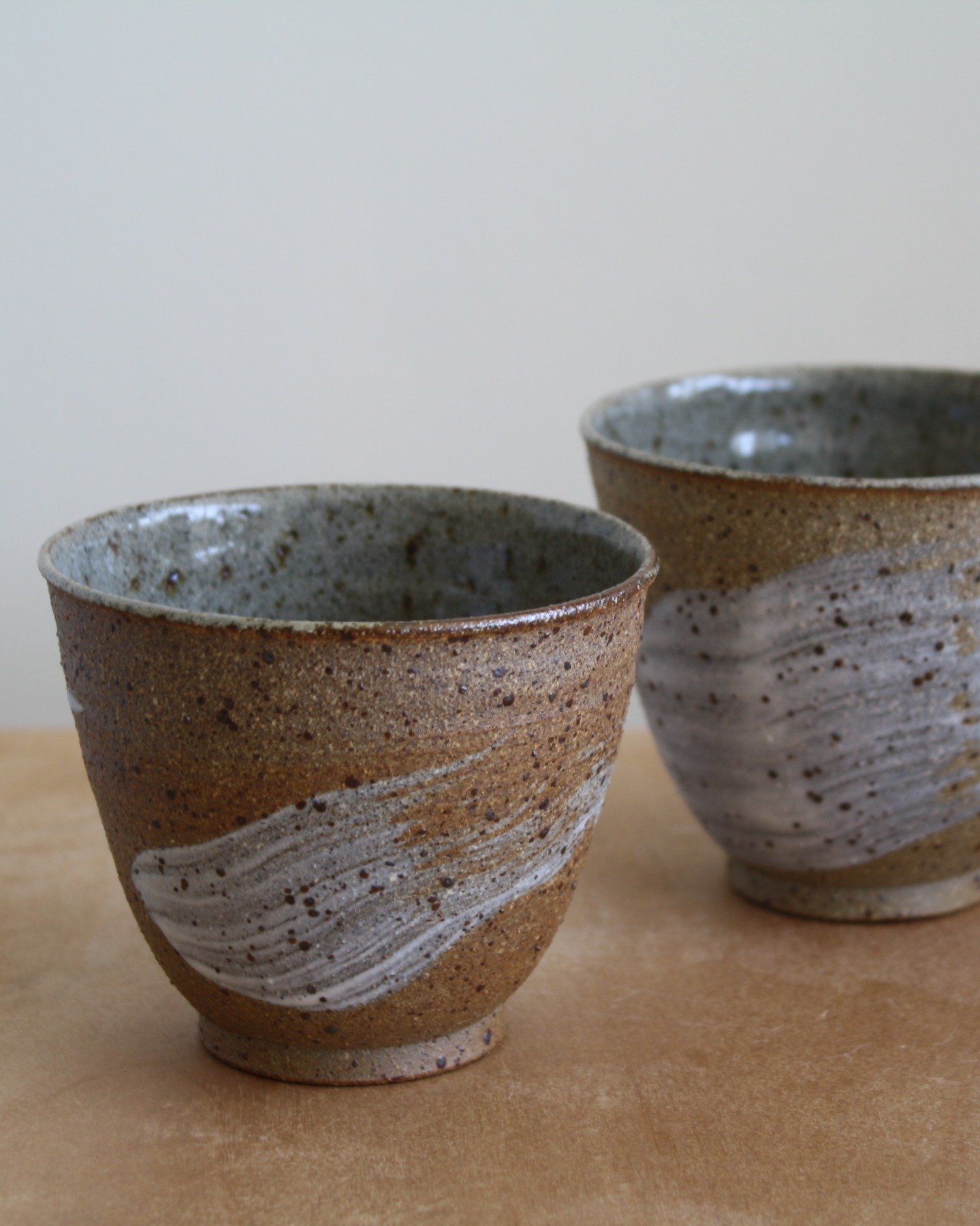 More reduction fired cups with porcelain slip brushstrokes from the recent gas firing @countyhallpottery. Unglazed raw clay on the outside and glazed on the inside. 

#gasfired #handmadeceramics #porcleainslip