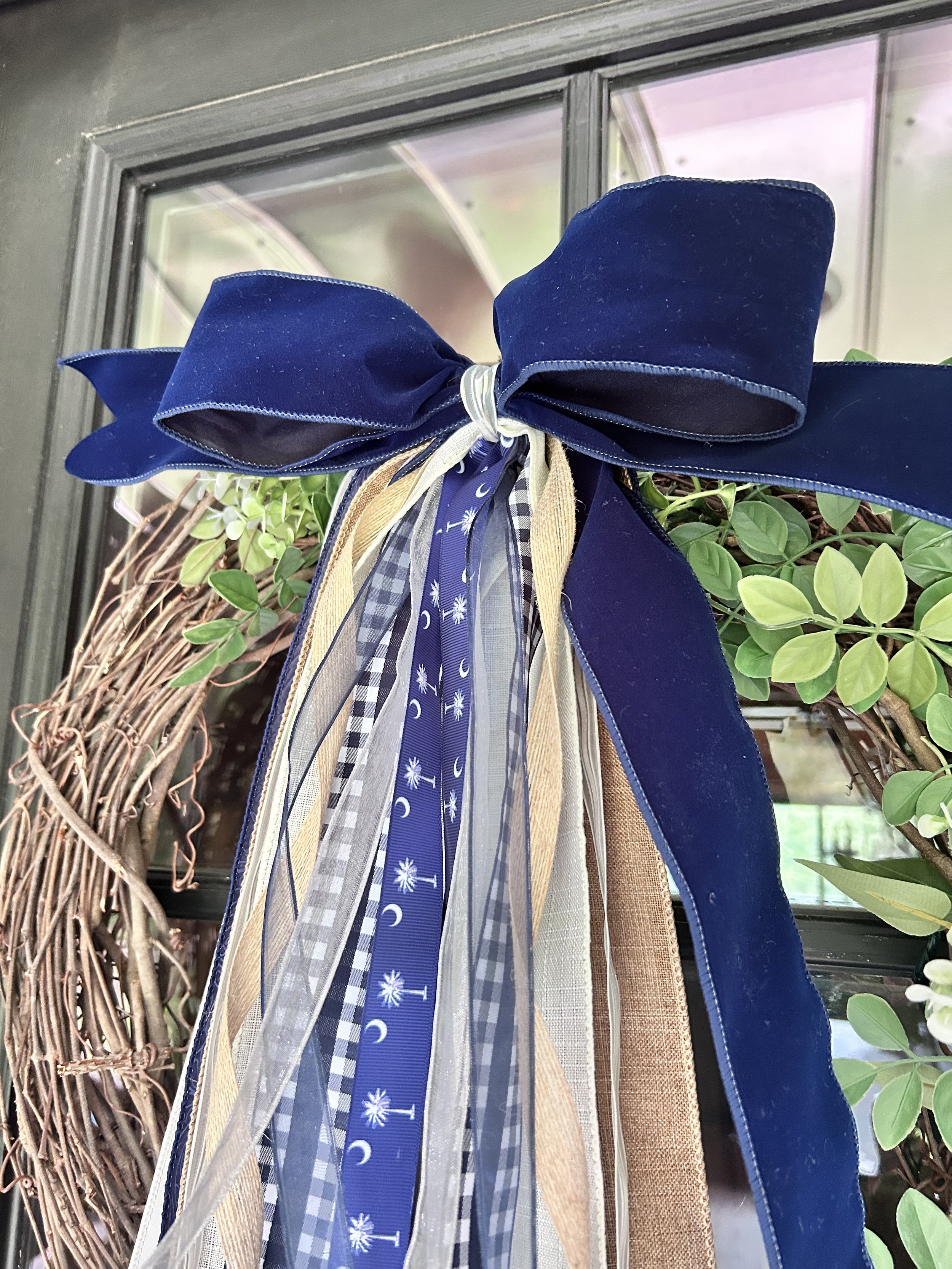 Palmetto Nights South Carolina bow with navy ribbon, palmetto print, gingham, burlap and ivory ribbon displayed on a grapevine wreath