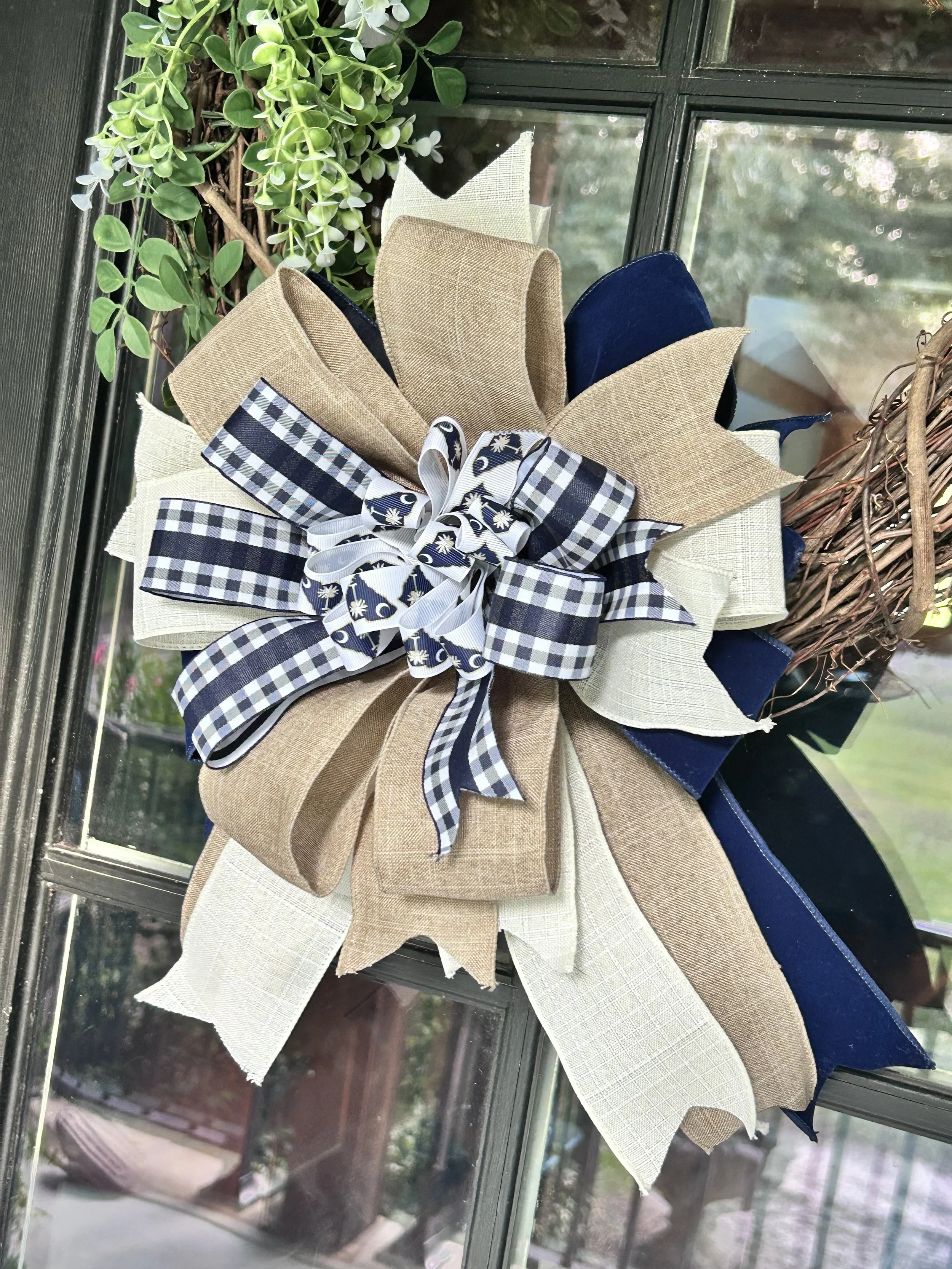 Palmetto Porch Bow with navy, natural linen, ivory, gingham and South Carolina palmetto ribbon displayed on a grapevine wreath
