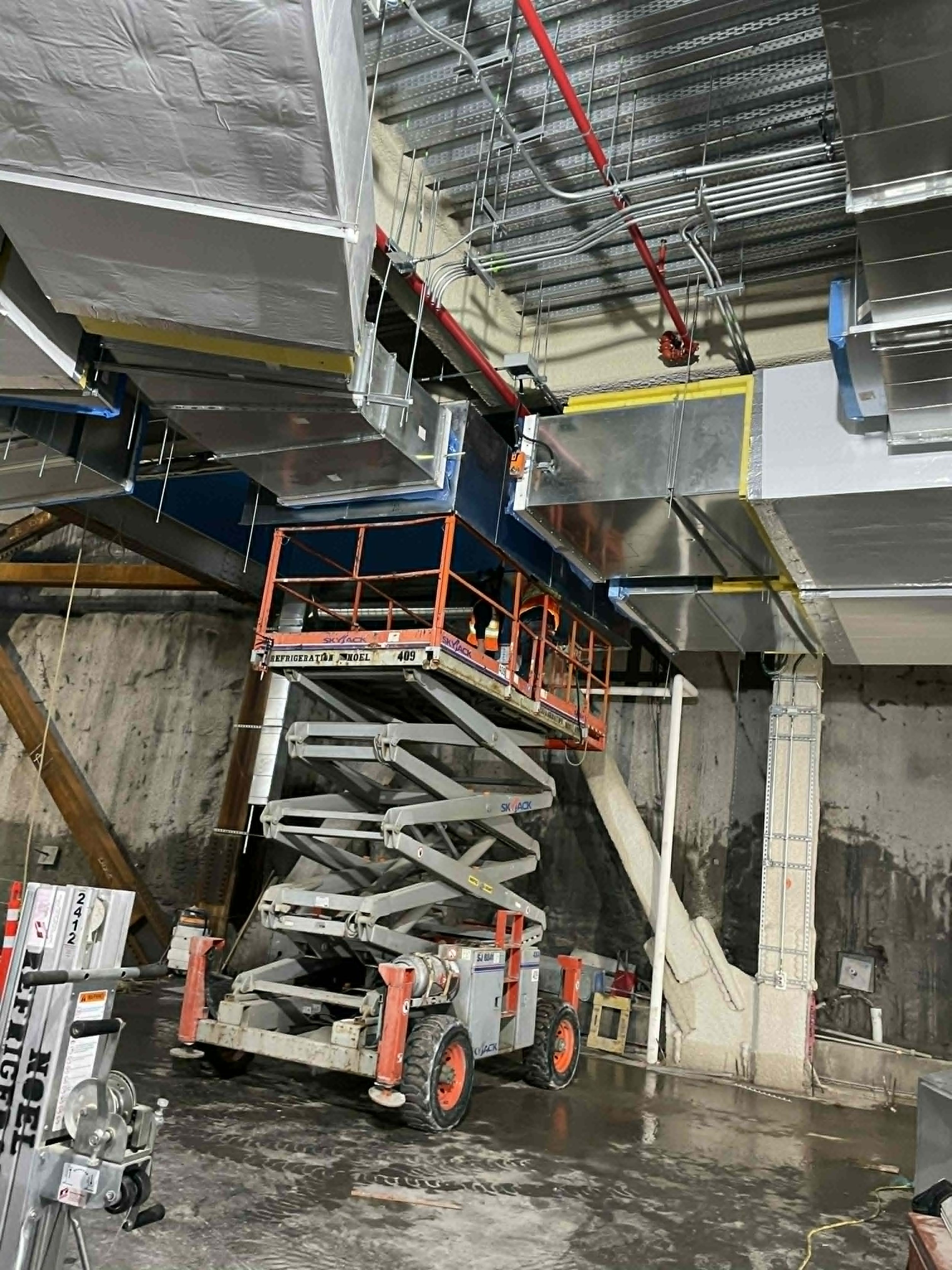 Construction de plafonds ou de dalles suspendues avec échafaudages et équipements de bâtiment dans un espace intérieur.