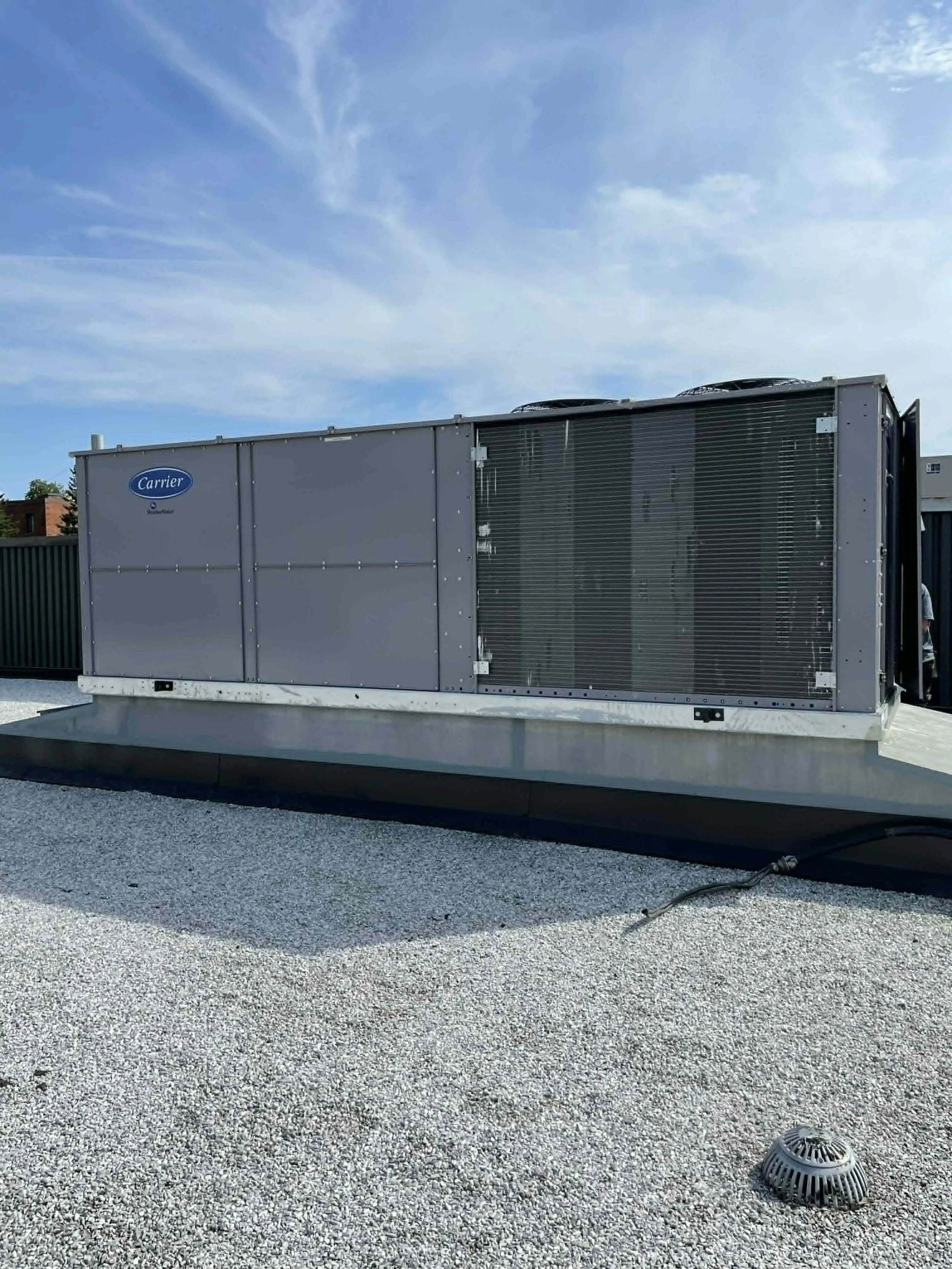 Un équipement de climatisation ou de refroidissement installé sur un toit avec un ciel bleu en arrière-plan.