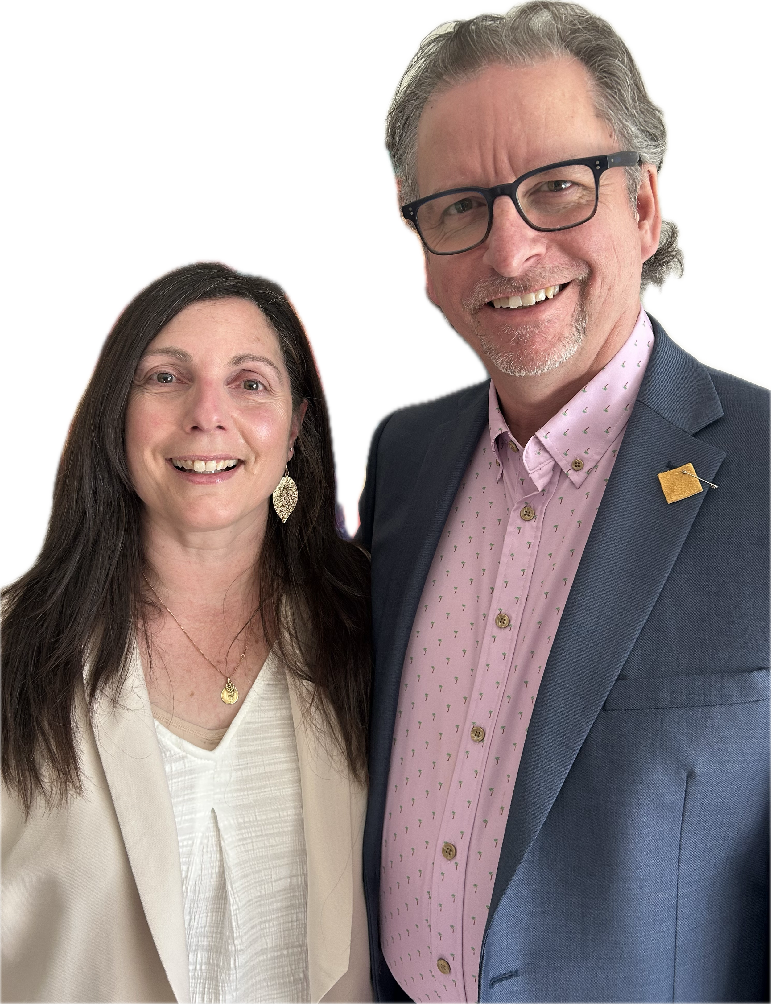 A man and a woman smiling for a photo, dressed in business attire, standing close together against a black background.