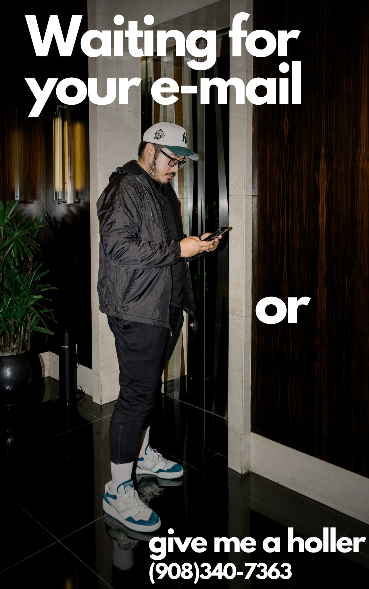 A man wearing black jacket, white and blue sneakers, white shorts, and a gray baseball cap with a NY logo, standing in an elevator lobby, looking at his phone, with large white text overlay that says 'Waiting for your e-mail or give me a holler (908)340-7363'.