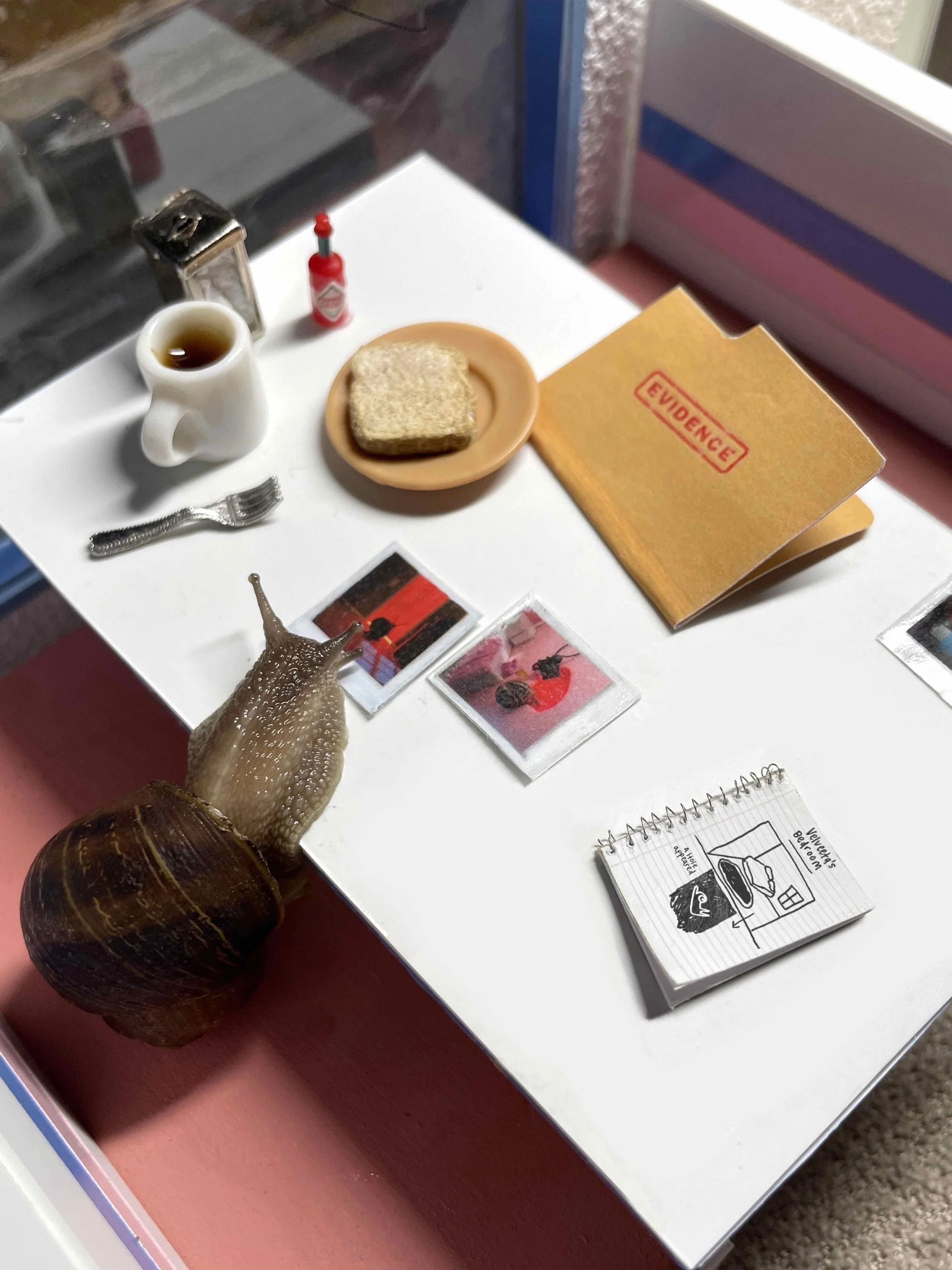 Miniature scene with a snail having breakfast in a small diner, surrounde by documents. They seem to be investigating something suspicious...