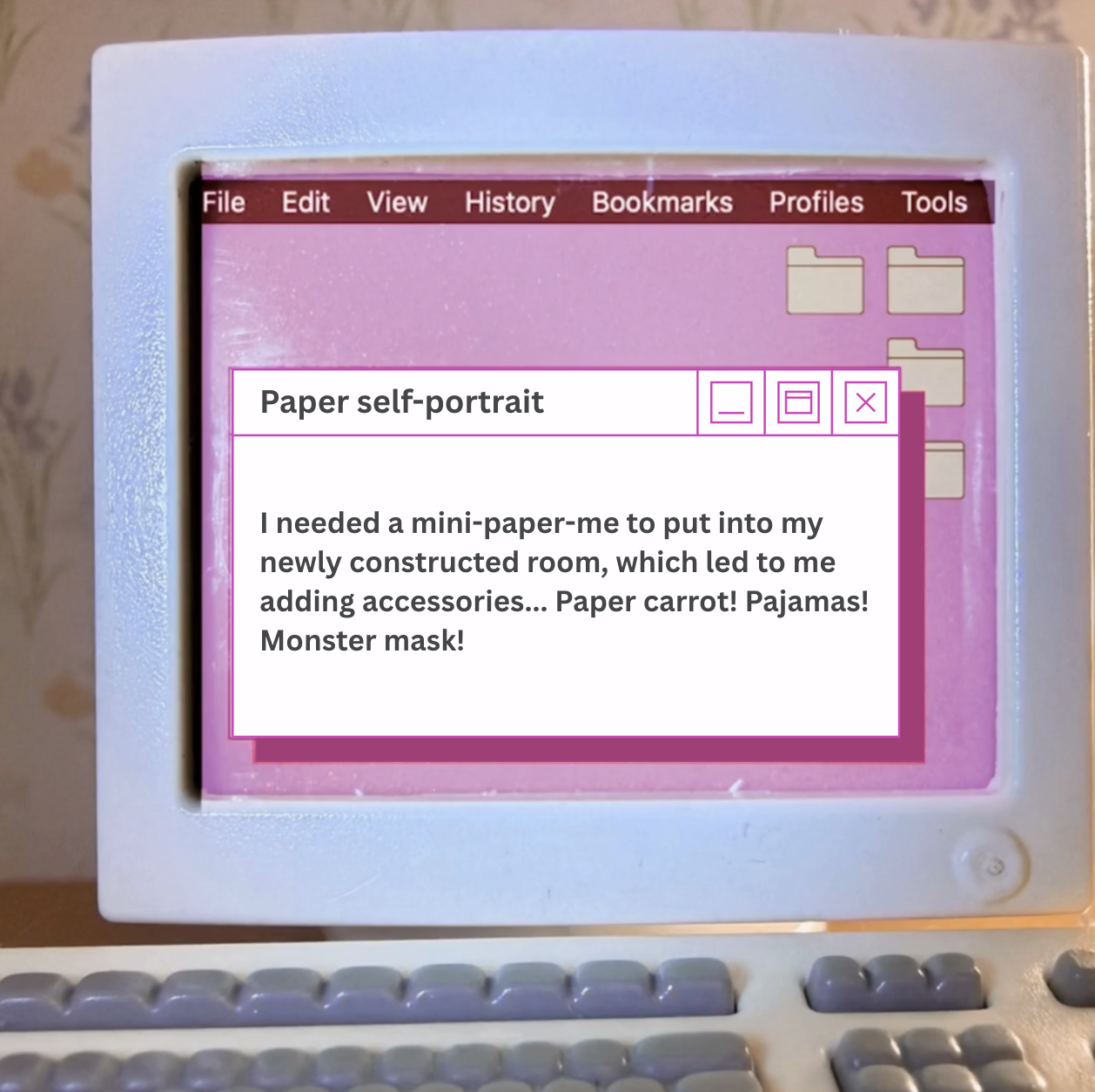 A vintage computer screen displaying a handwritten note about making a paper self-portrait, with a pink and purple interface and folders visible on the desktop.