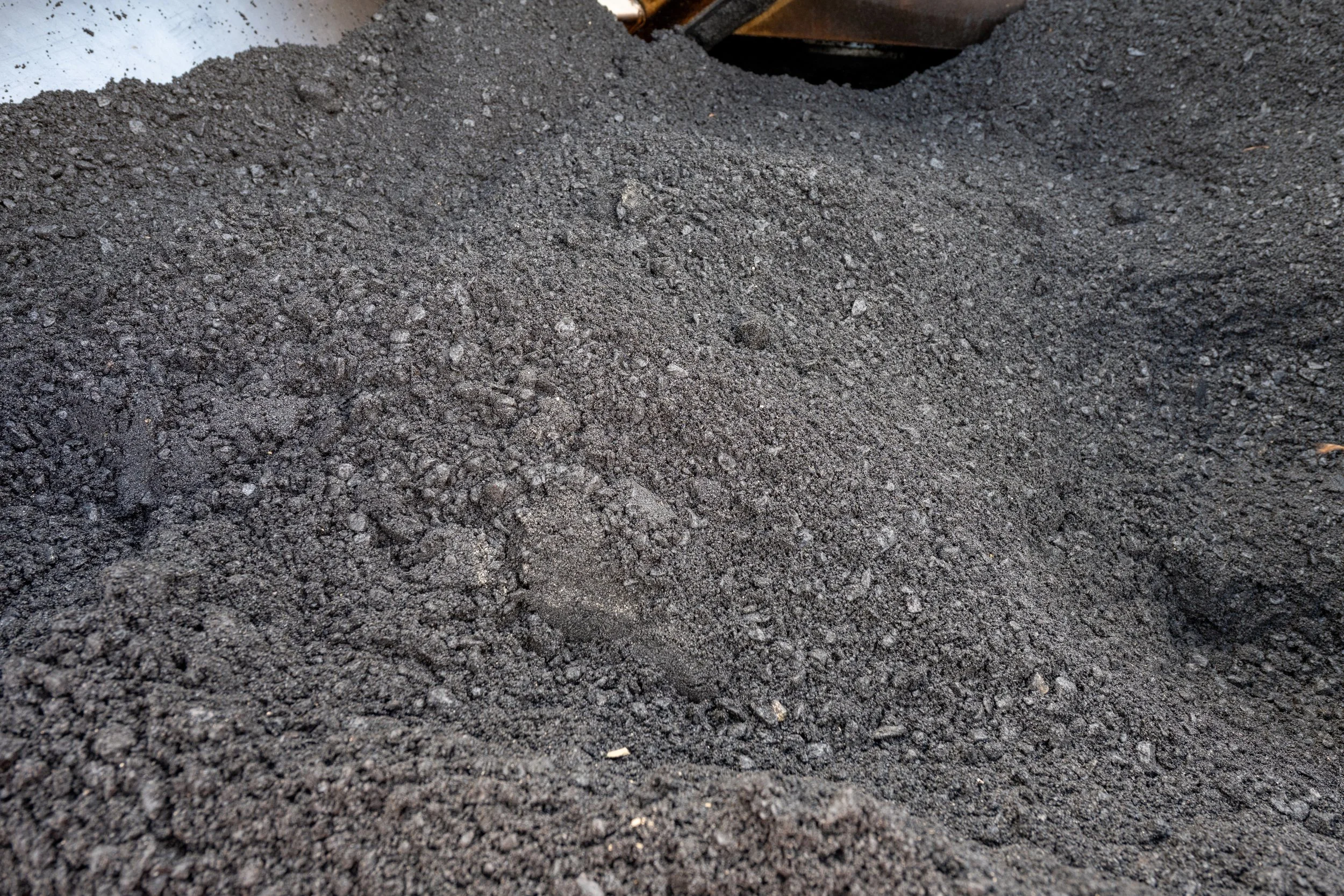 A pile of dark black soil or gravel.