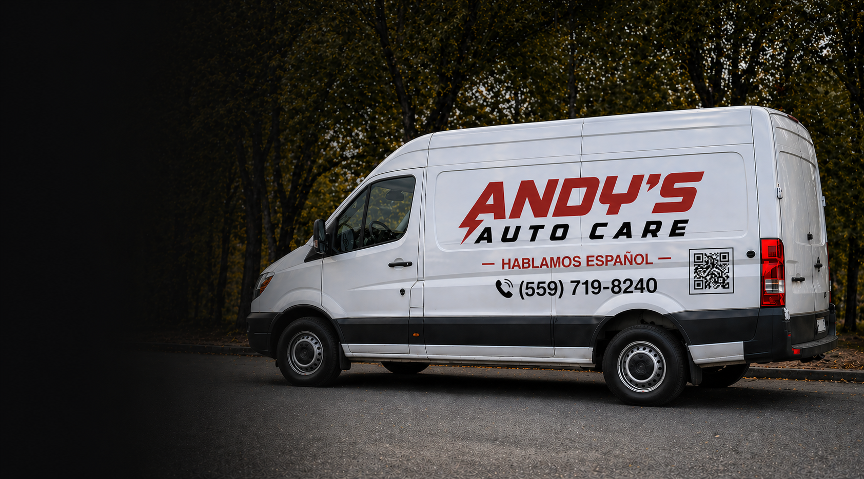White repair van with red and black text and QR code parked on street with trees in background.