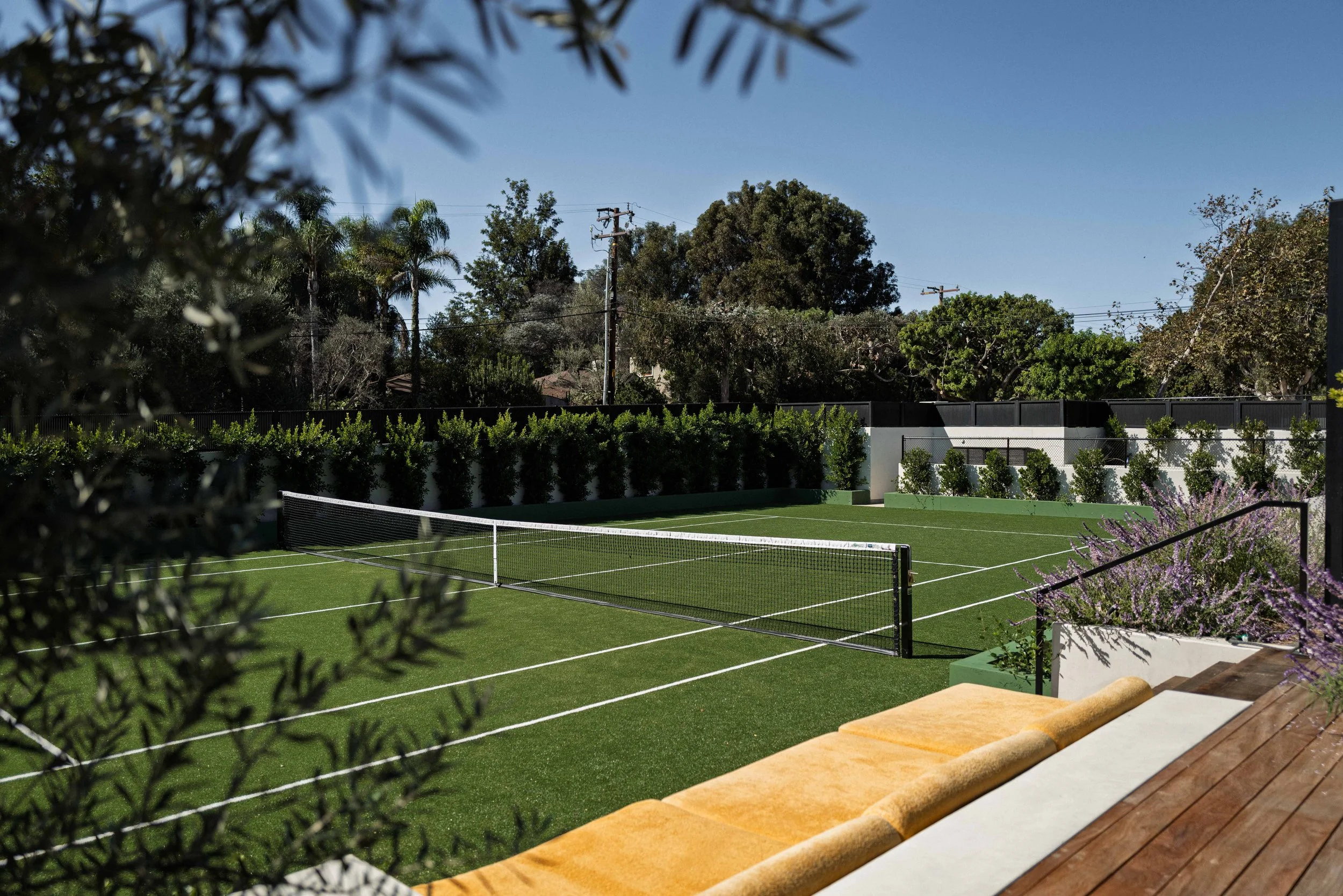Tennis court framed by olive branches and garden hedges, Malibu estate photography
