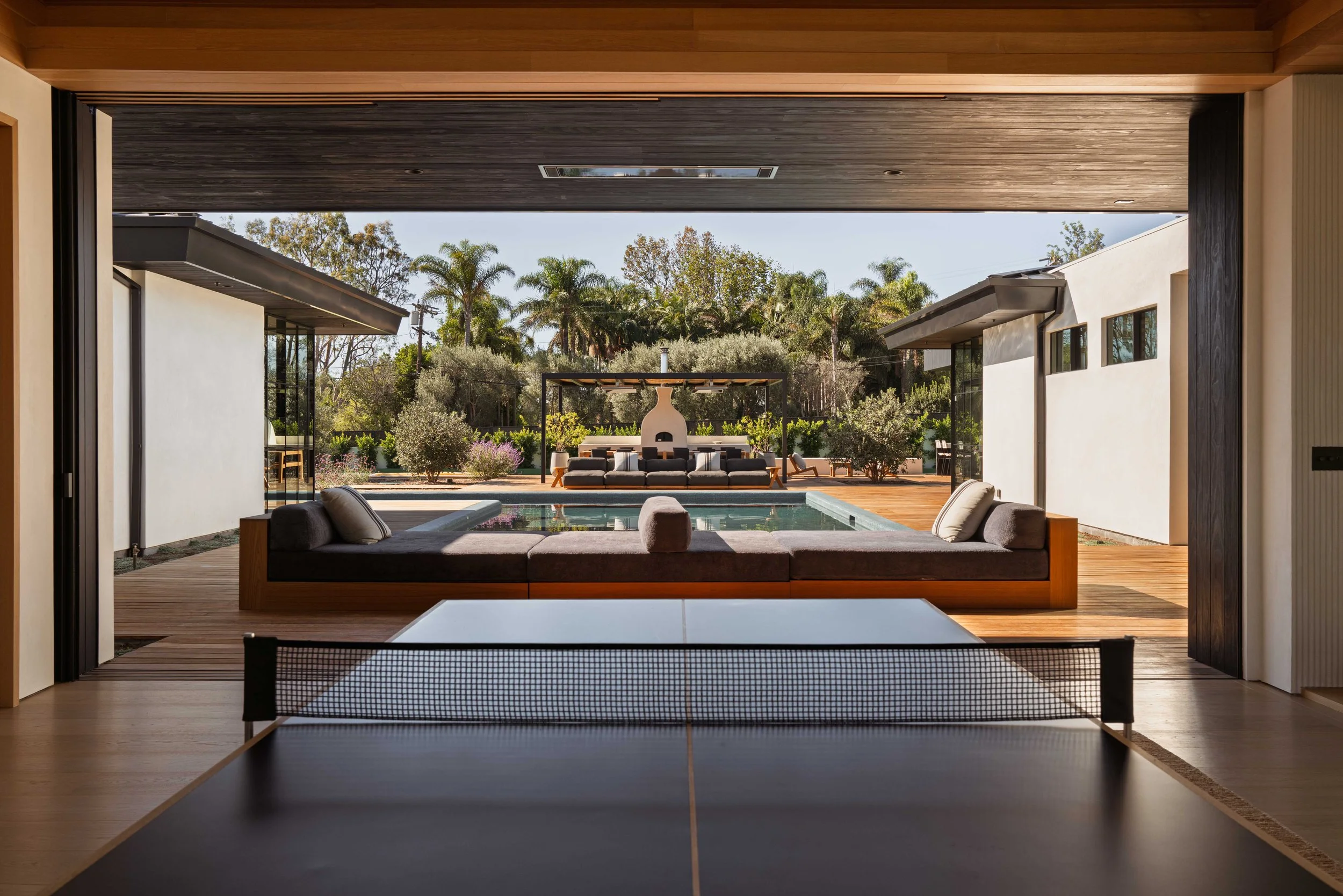 Indoor-outdoor living room opening onto the pool and garden, Point Dume Malibu home by Peggy North / Fire and creme