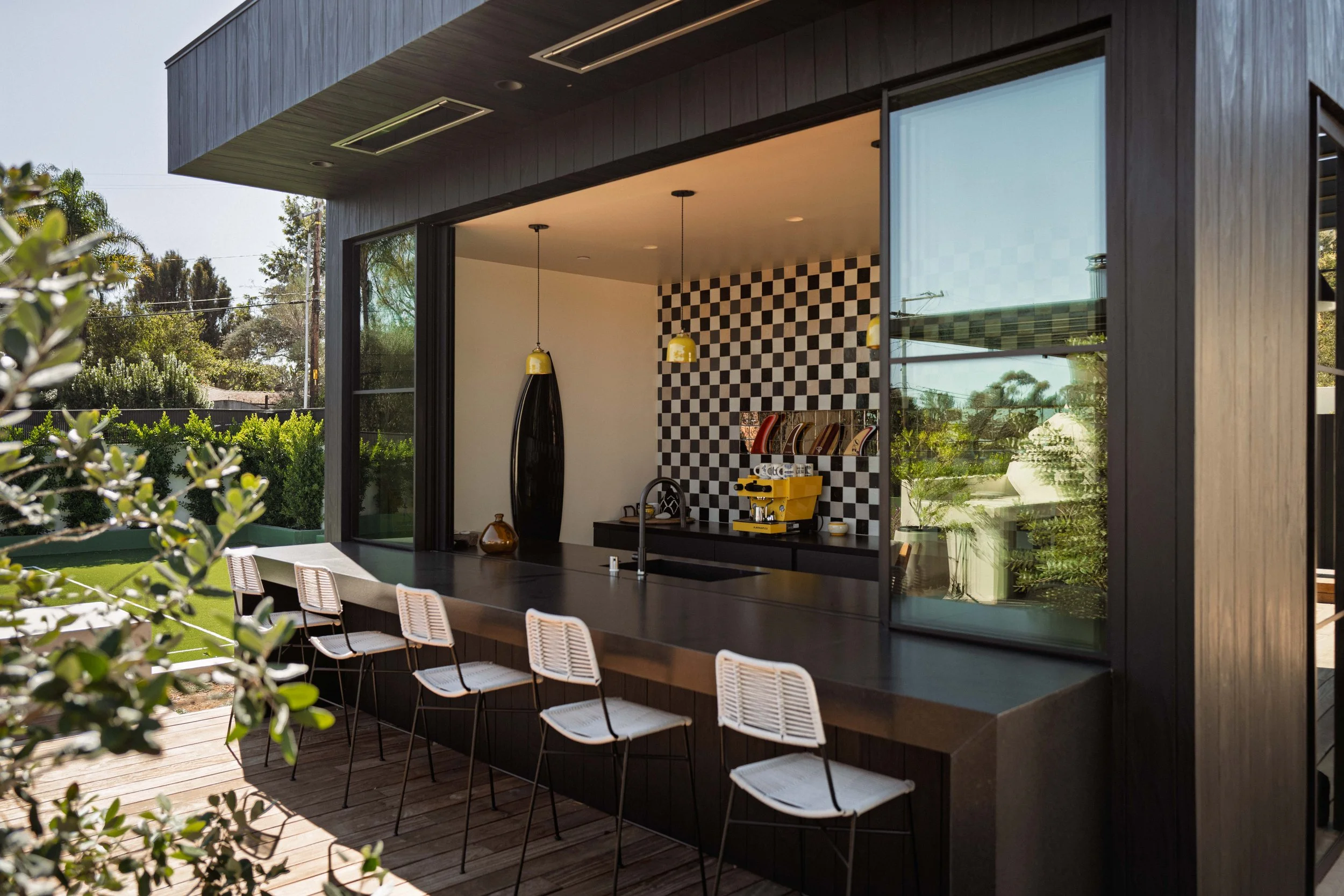 Black kitchen bar  surf shack with white stools and checkered Zellige tile backsplash, Point Dume Malibu home