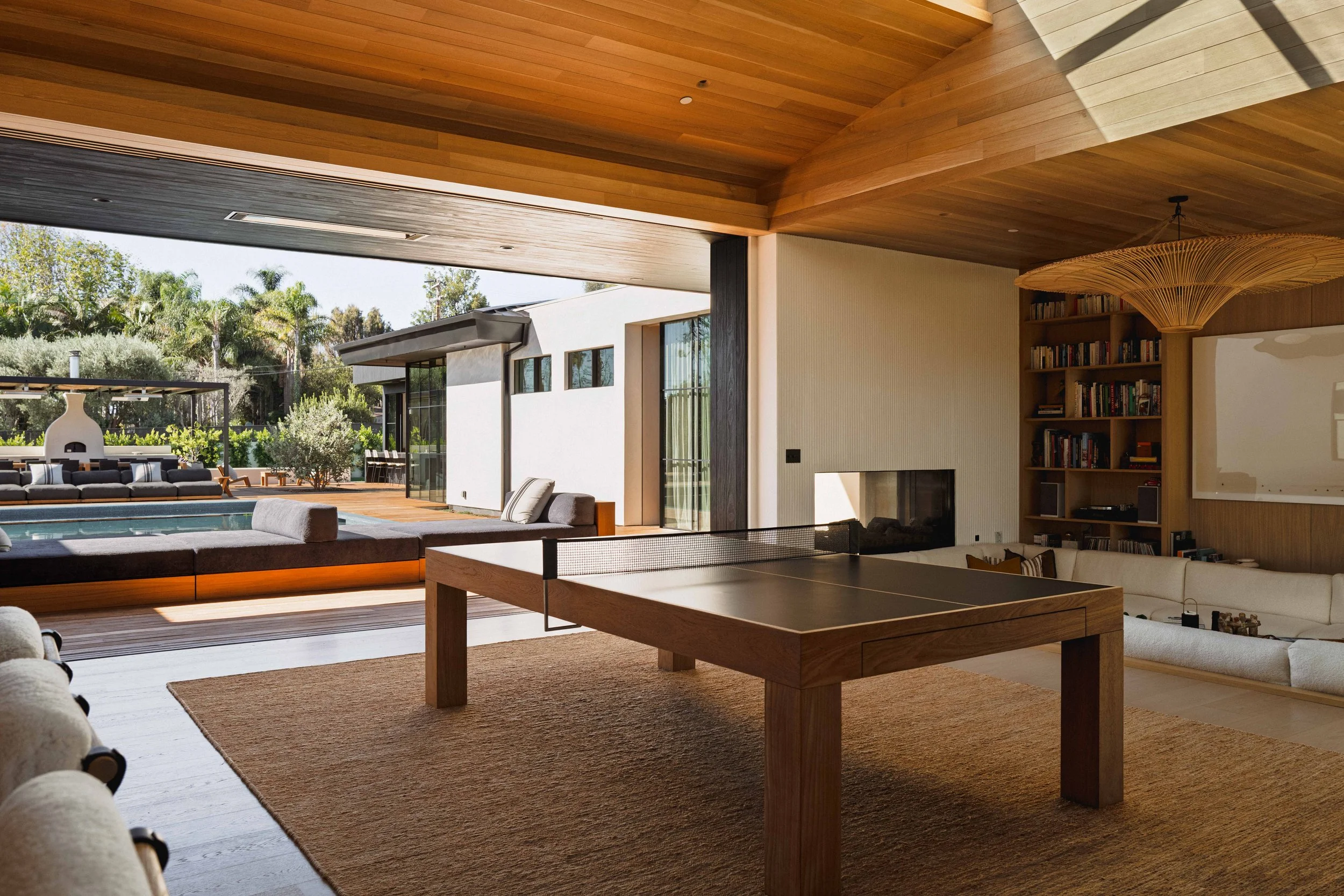 Game room with ping-pong table, fireplace, and wood-paneled ceiling, Point Dume home