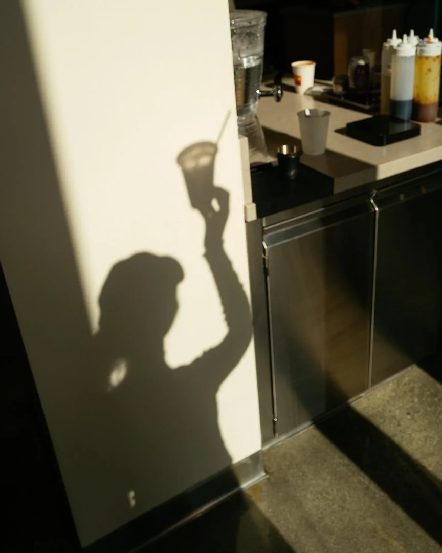 Shadow of a hand raising a coffee cup on the bakery wall, Louma Bakery Santa Monica
