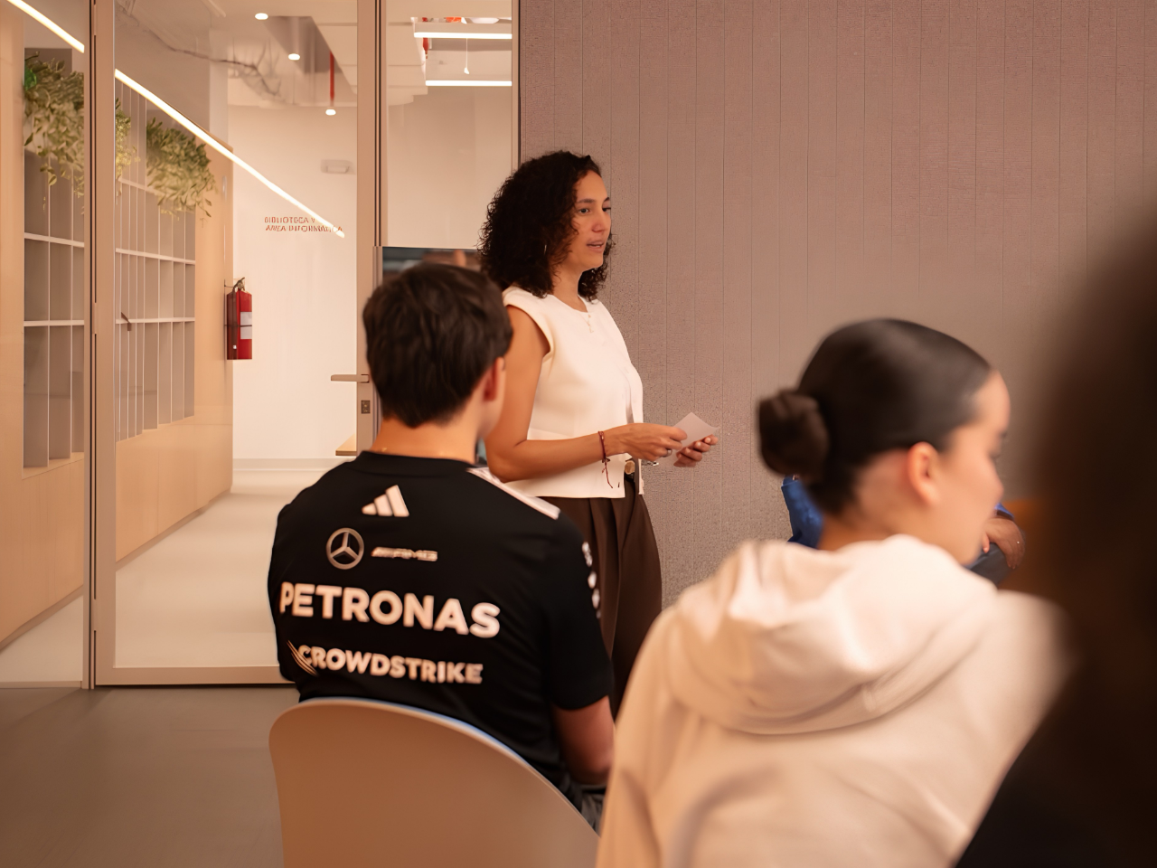 Ana Lobos guiando un taller con jóvenes sentados en una sala moderna. Universidad Central - Panamá