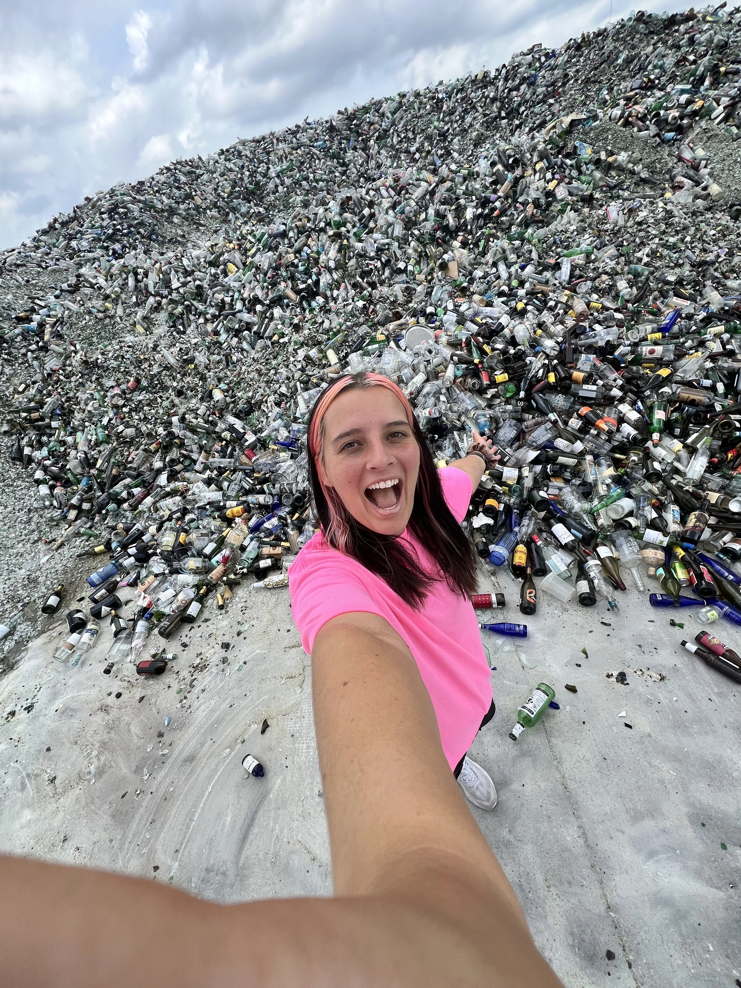Franziska Traumann, keynote speaker and TikToker, smiles in front of her pile of glass. Book Franziska for your conference, event, college campus, or any speaking engagement.