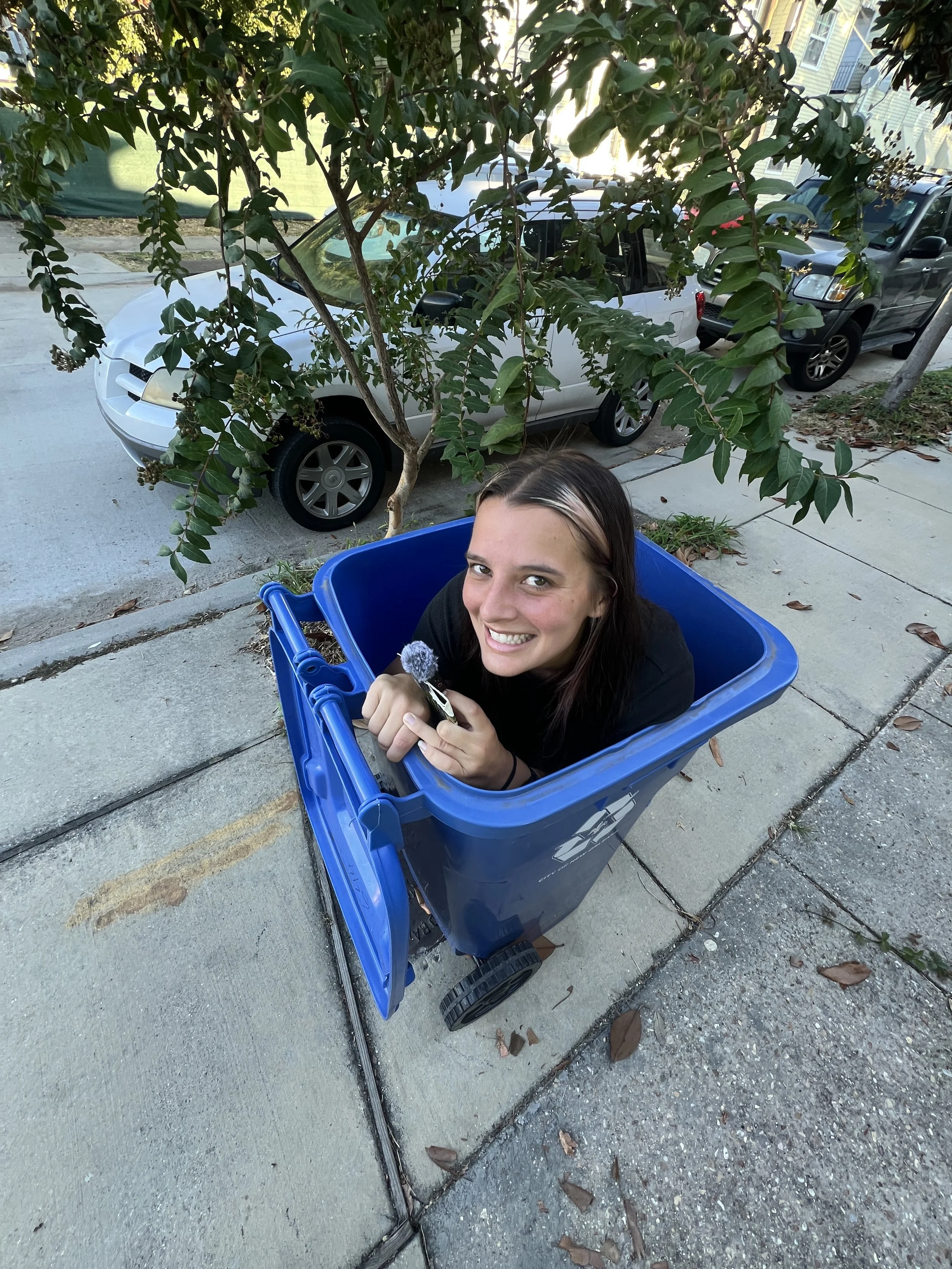 Franziska Trautmann (glass girl) smiles while sitting inside of a recycling bin. Franziska Trautmann speaks on recycling, coastal restoration, entrepreneurship, founder journey, inspiration, motivation, and more.