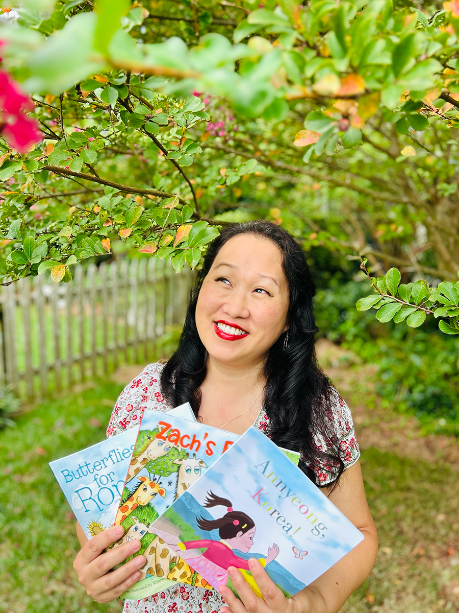 Kim Ellis photo with three books.png