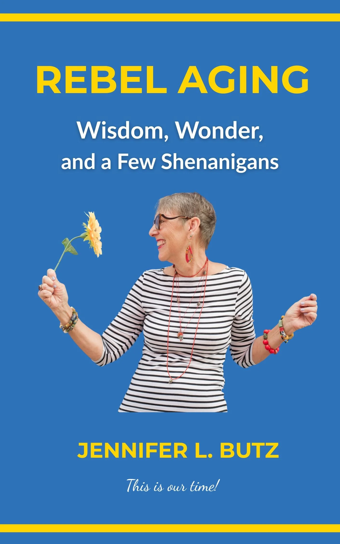 Book cover titled "Rebel Aging: Wisdom, Wonder, and a Few Shenanigans" by Jennifer L. Butz. Features a smiling older woman with short gray hair, wearing glasses, a striped shirt, and colorful jewelry, holding a sunflower in one hand and gesturing with the other against a blue background.