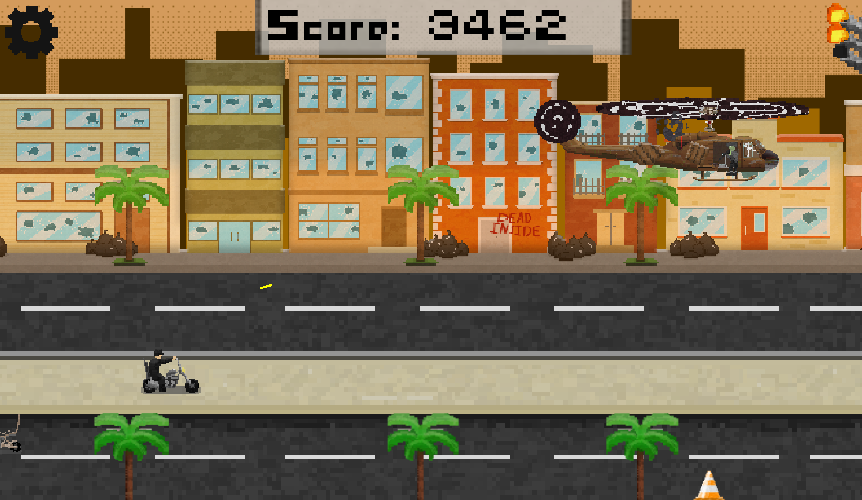 Pixel art-style city scene with buildings, palm trees, and a helicopter flying in the sky. A person is riding a motorcycle on the road and a pavement cone is on the street. The score displayed at the top is 3462.