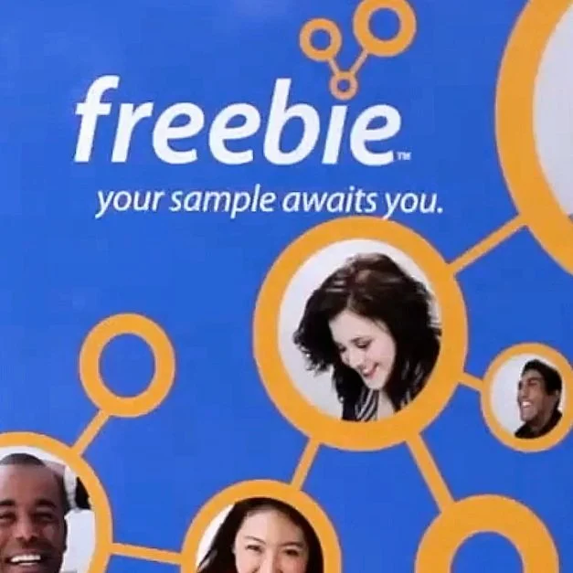 Marketing flyer with the word 'freebie' in large white letters, a slogan 'your sample awaits you,' and images of smiling diverse people connected by orange circles and lines on a blue background.