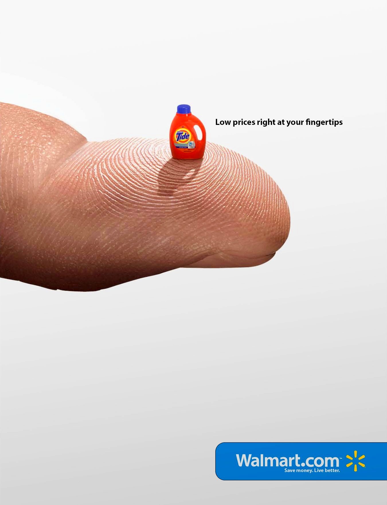 A close-up of a finger with a small bottle of Tide laundry detergent placed on the fingertip, with Walmart branding visible in the bottom corner.