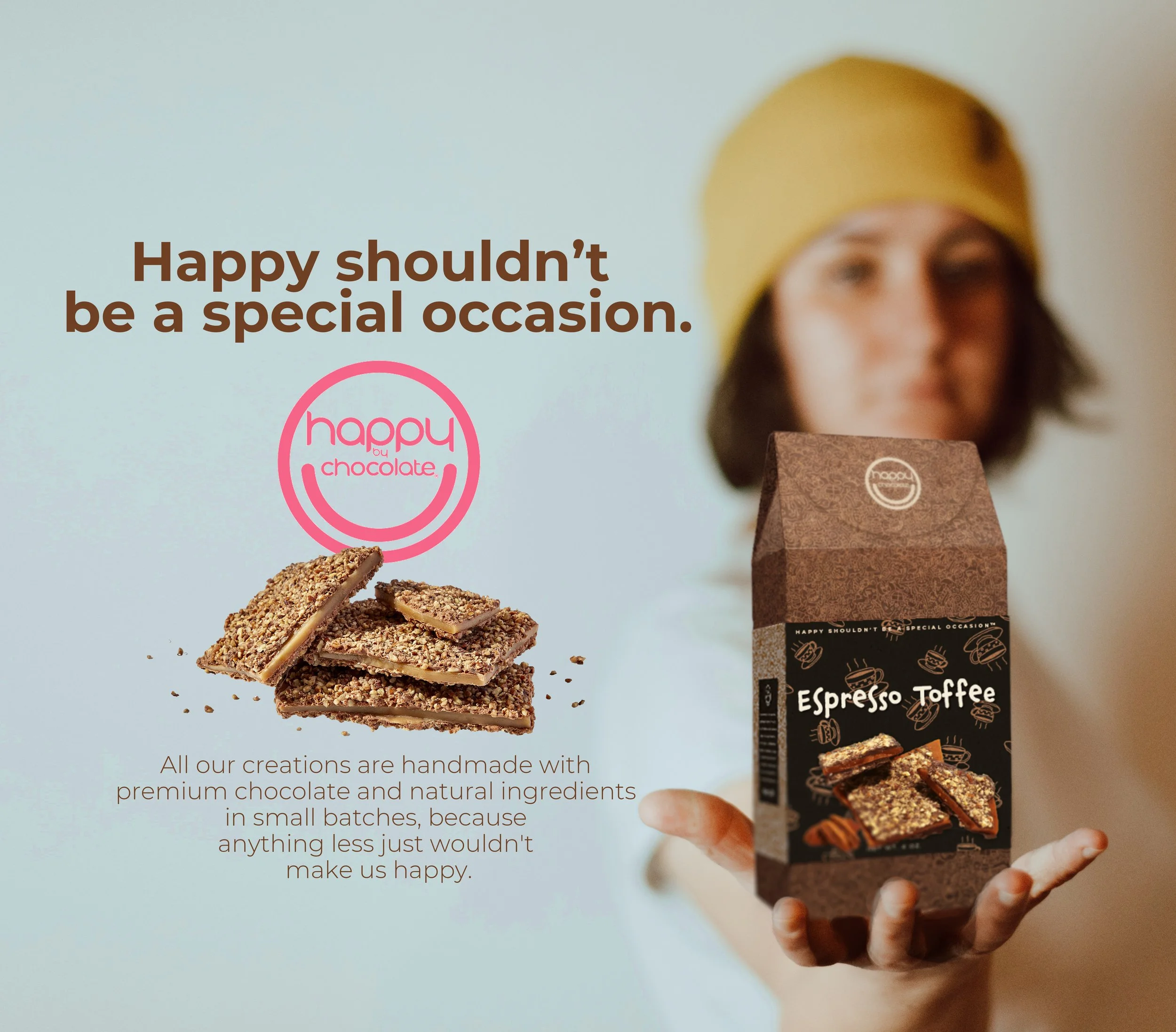 A person wearing a yellow beanie holding a box of espresso toffee chocolates with stacked toffee pieces in the foreground. The background features a motivational quote about happiness and handmade chocolates.