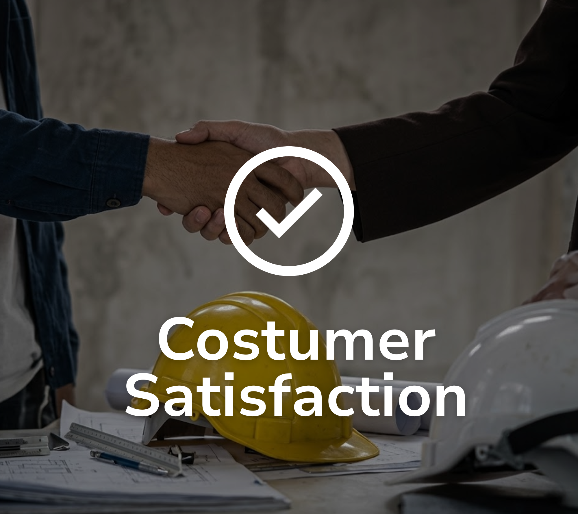 Close-up of two people shaking hands over a table with construction helmets, blueprints, and measuring tools, indicating agreement or satisfaction in construction or project planning.
