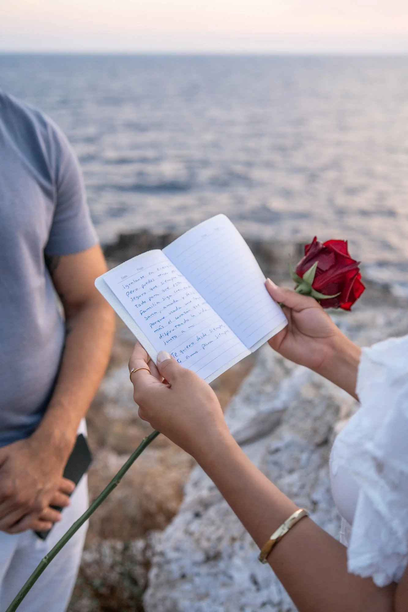 Detail shot of a couple writing their anniversary vows by the Mediterranean Sea in Southern Italy.