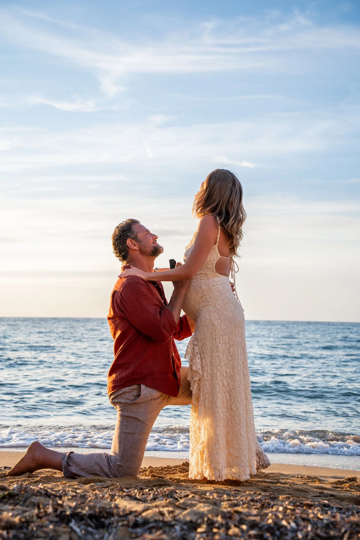 Man proposing to his girlfriend on the beach during a surprise proposal photoshoot in Gallipoli, Italy.