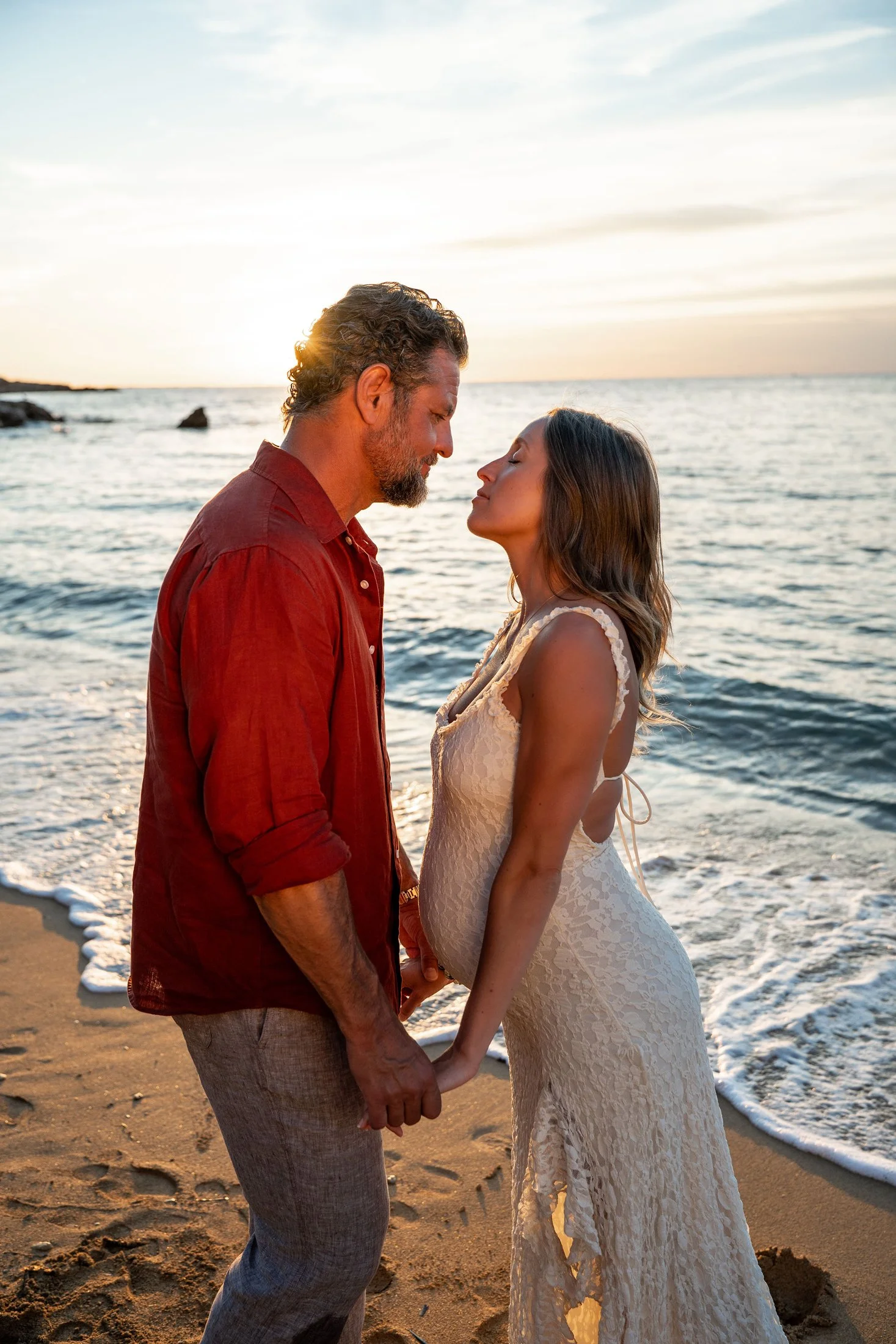 Romantic sunset portraits of a newly engaged expecting couple in Gallipoli, Puglia.