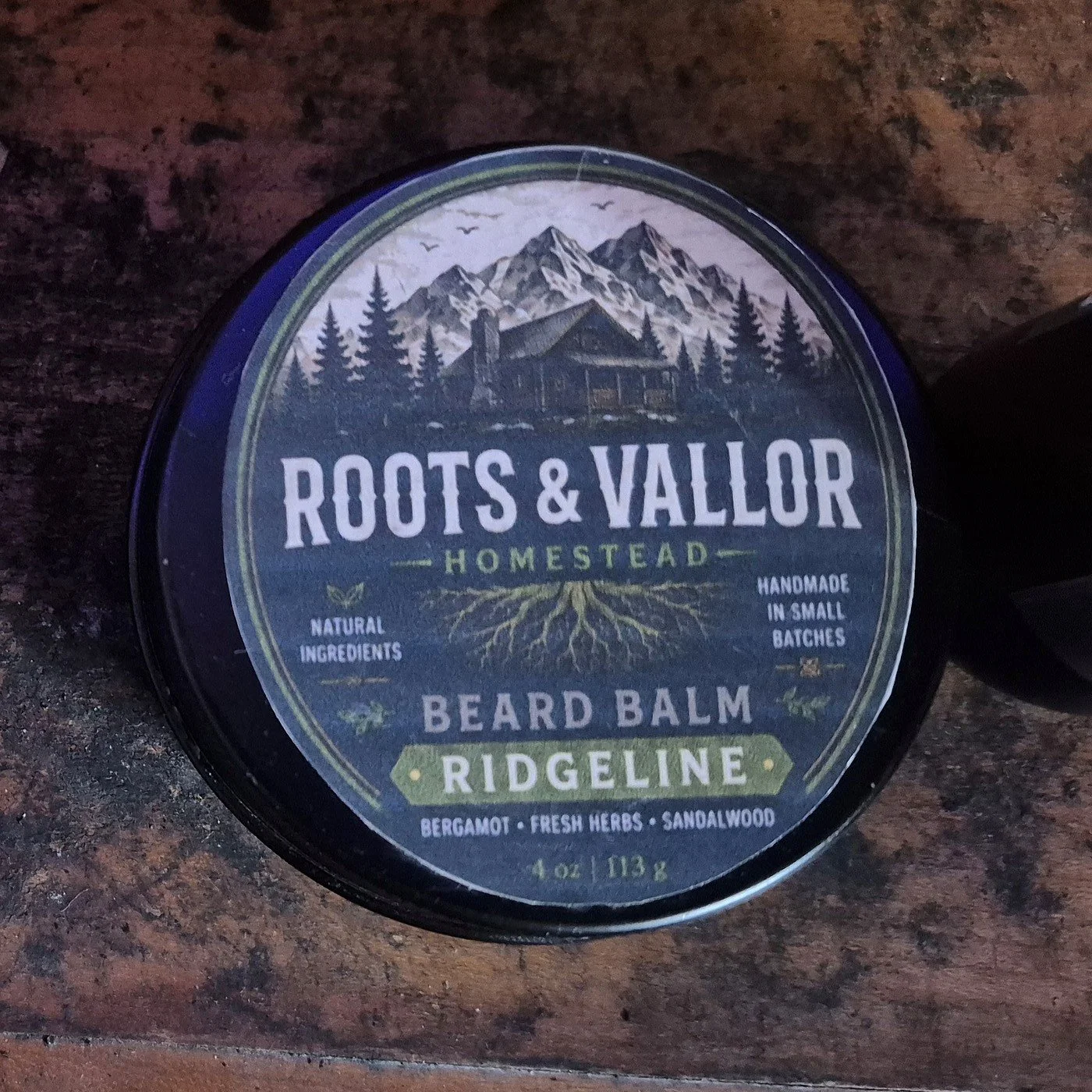 A real Roots and Vallor Ridgeline beard balm prototype tin on the homestead workbench.