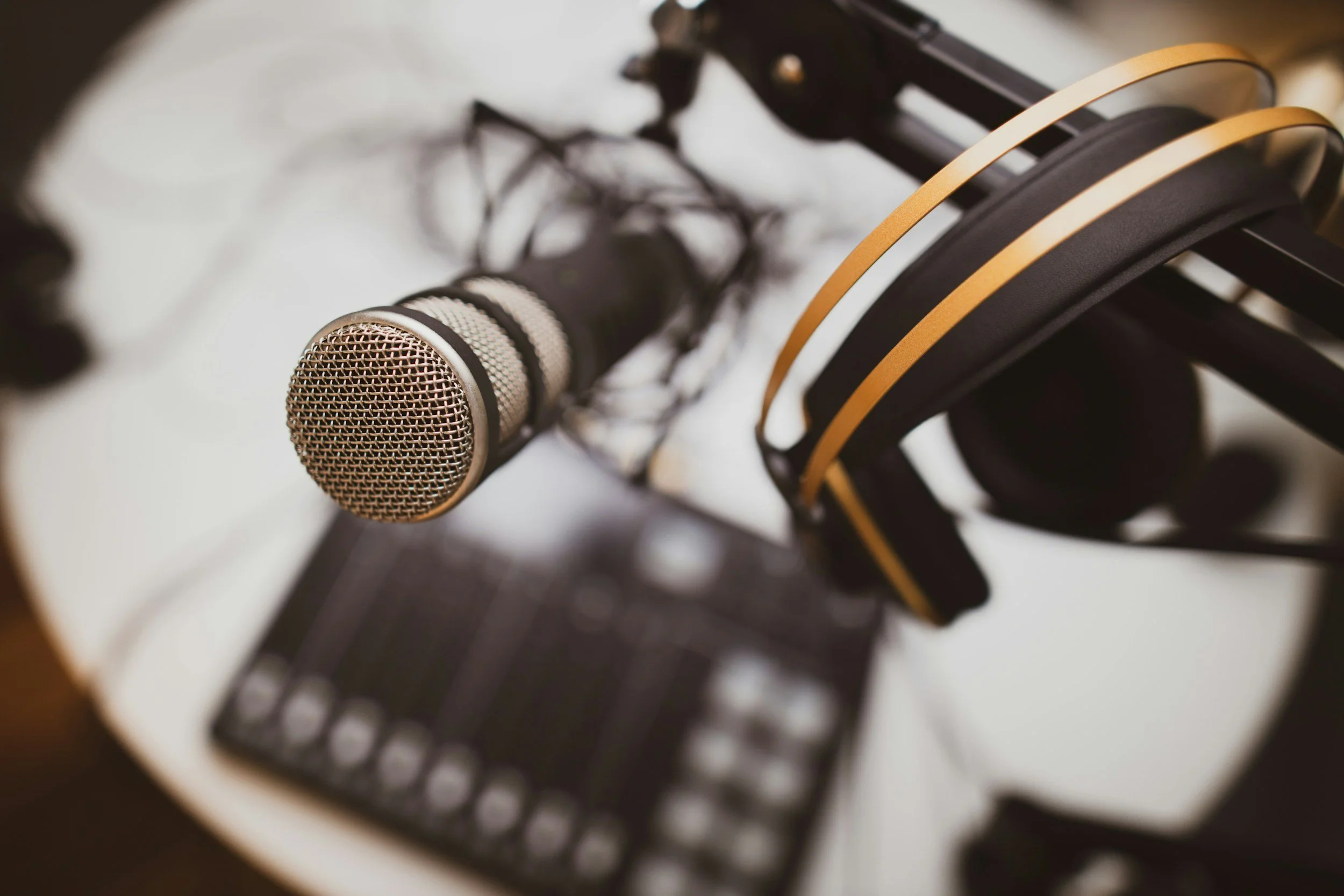 Over ear headphones hanging on a podcast mic stand. holding a mic