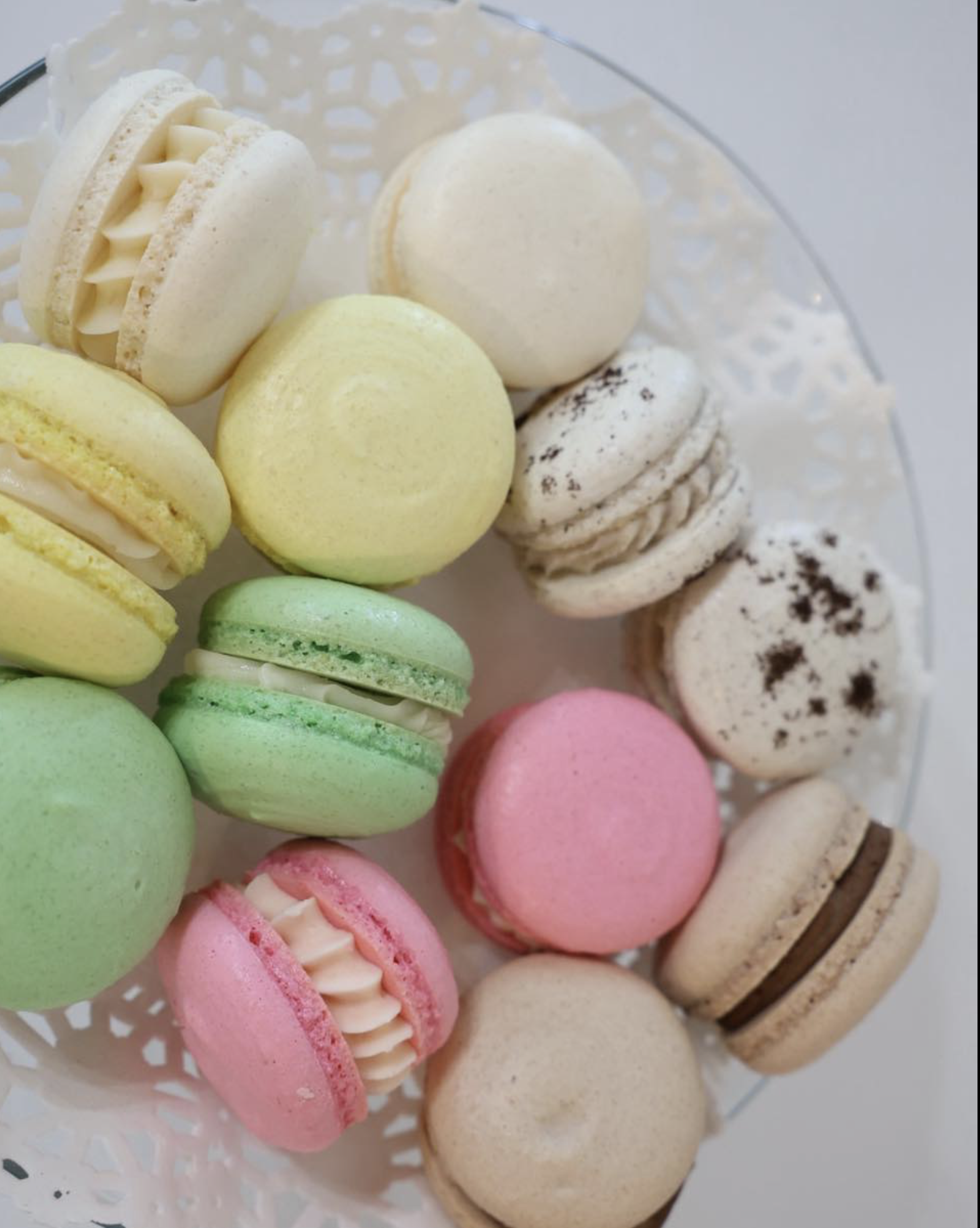 Assorted colorful macarons on a decorative plate.