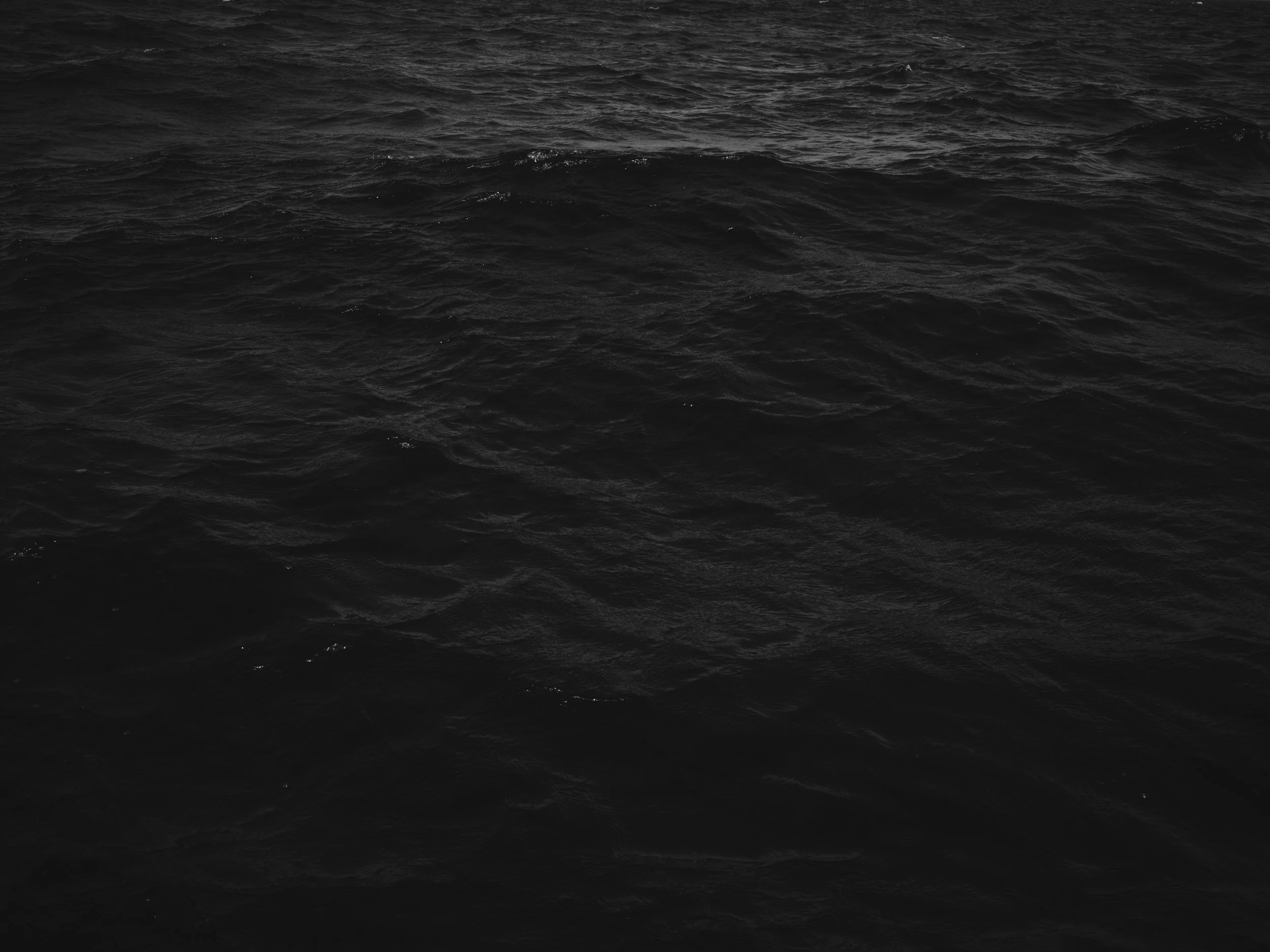 Black ocean water with gentle waves.