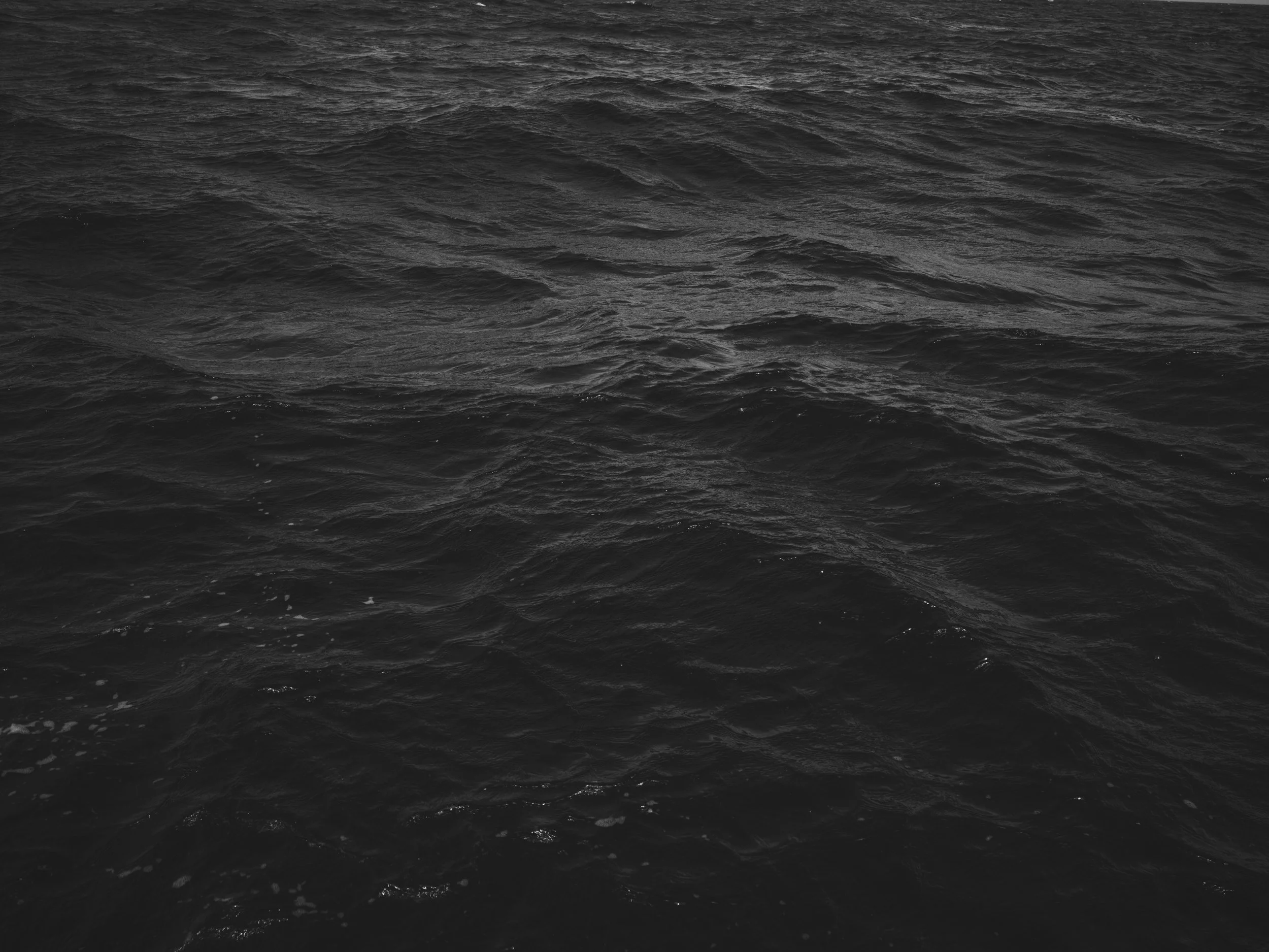 Black and white photo of choppy ocean water.