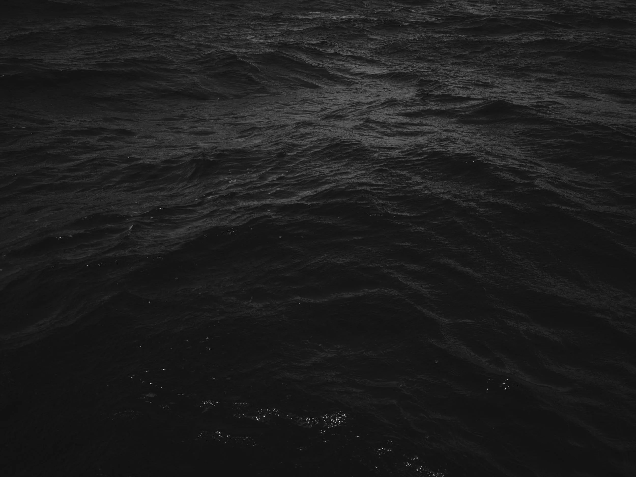Dark, choppy ocean water with waves on the surface.