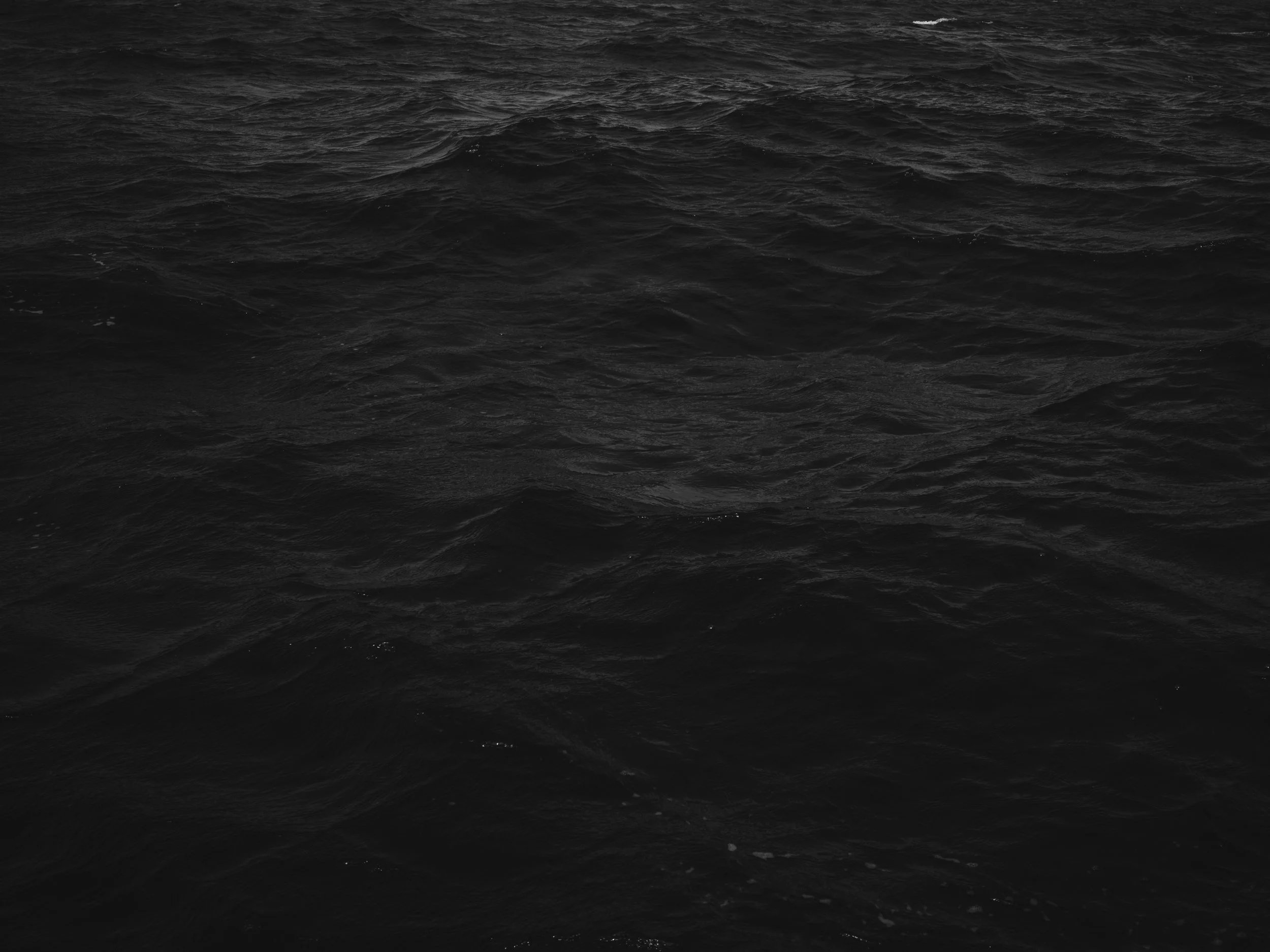 Dark, choppy ocean waves under a cloudy sky