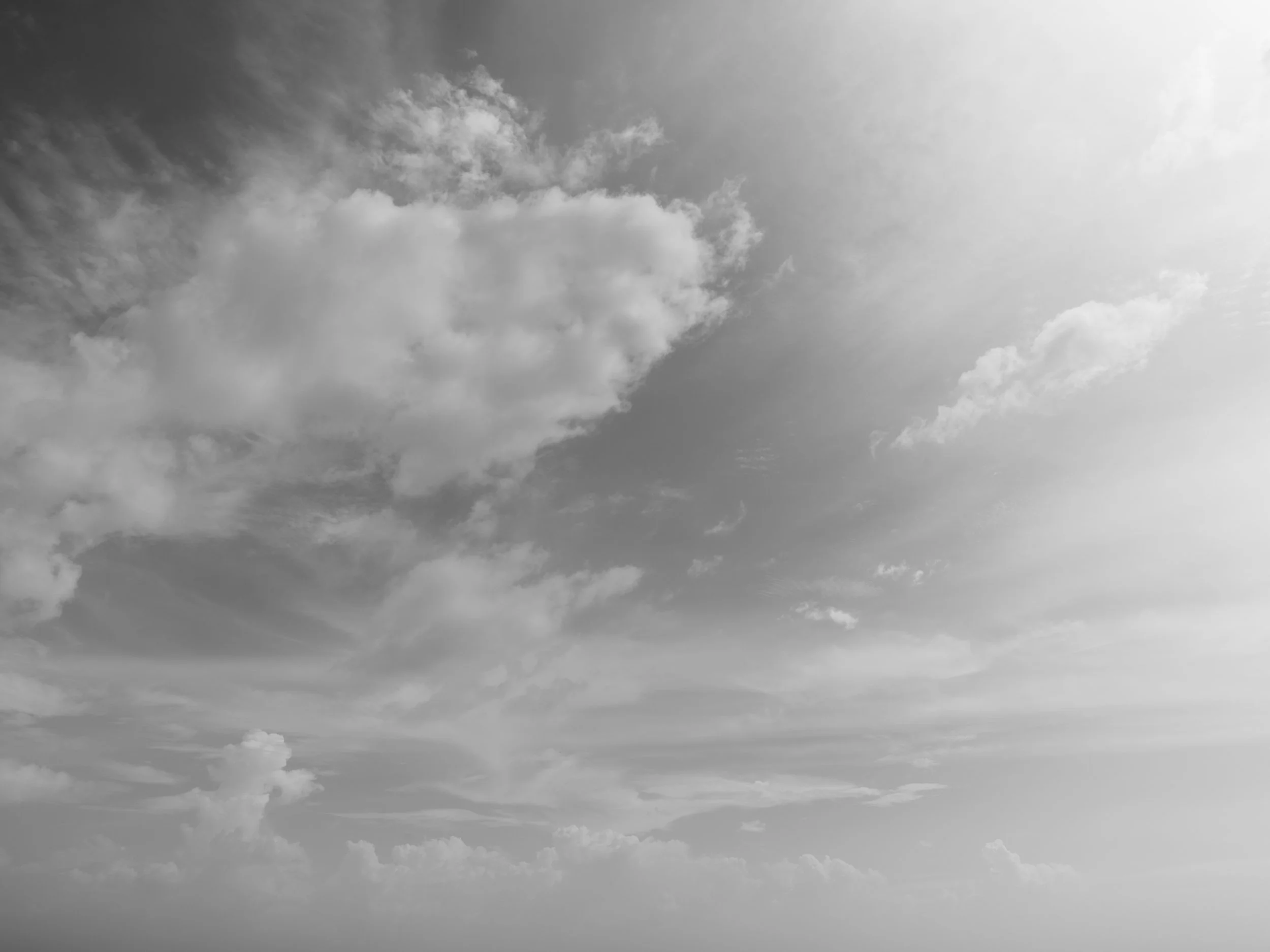 Black and white photo of a cloudy sky with various cloud formations