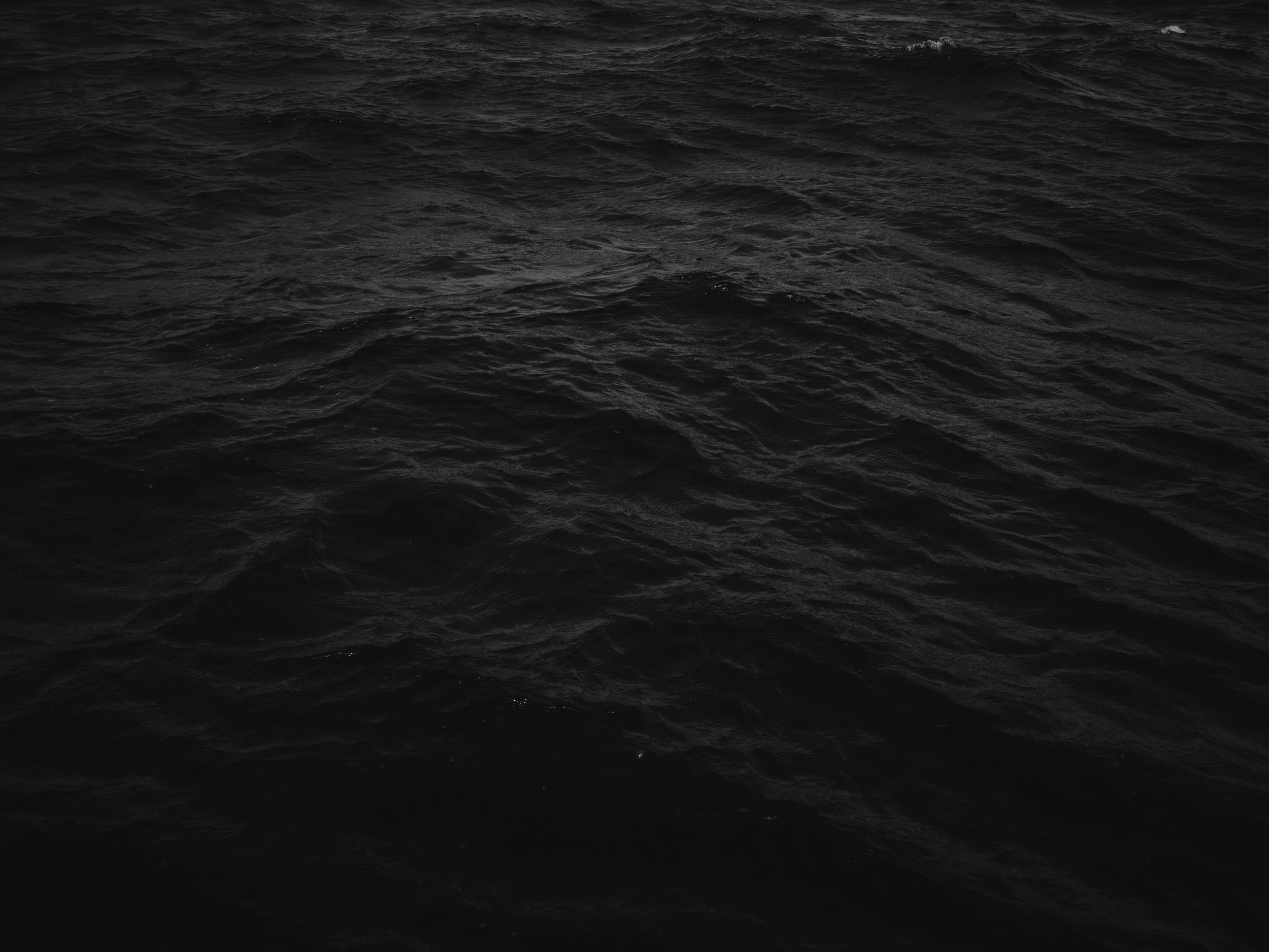 Dark, choppy ocean water in black and white.
