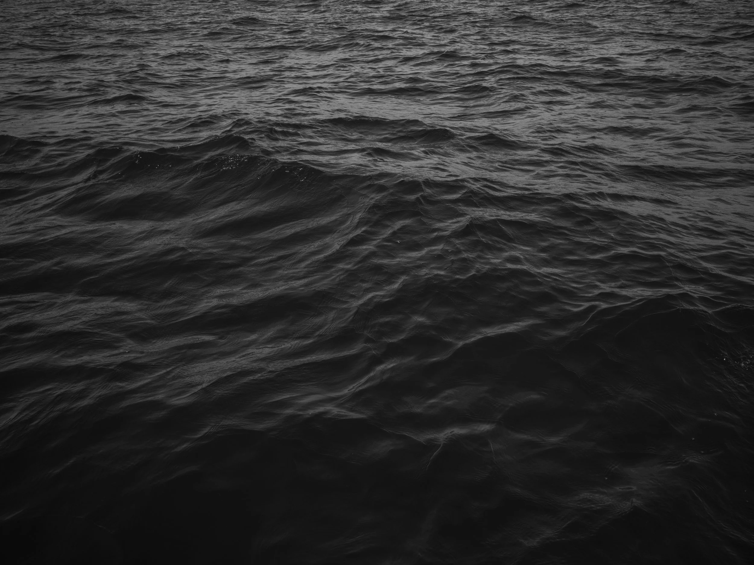Black ocean water with ripples and waves.