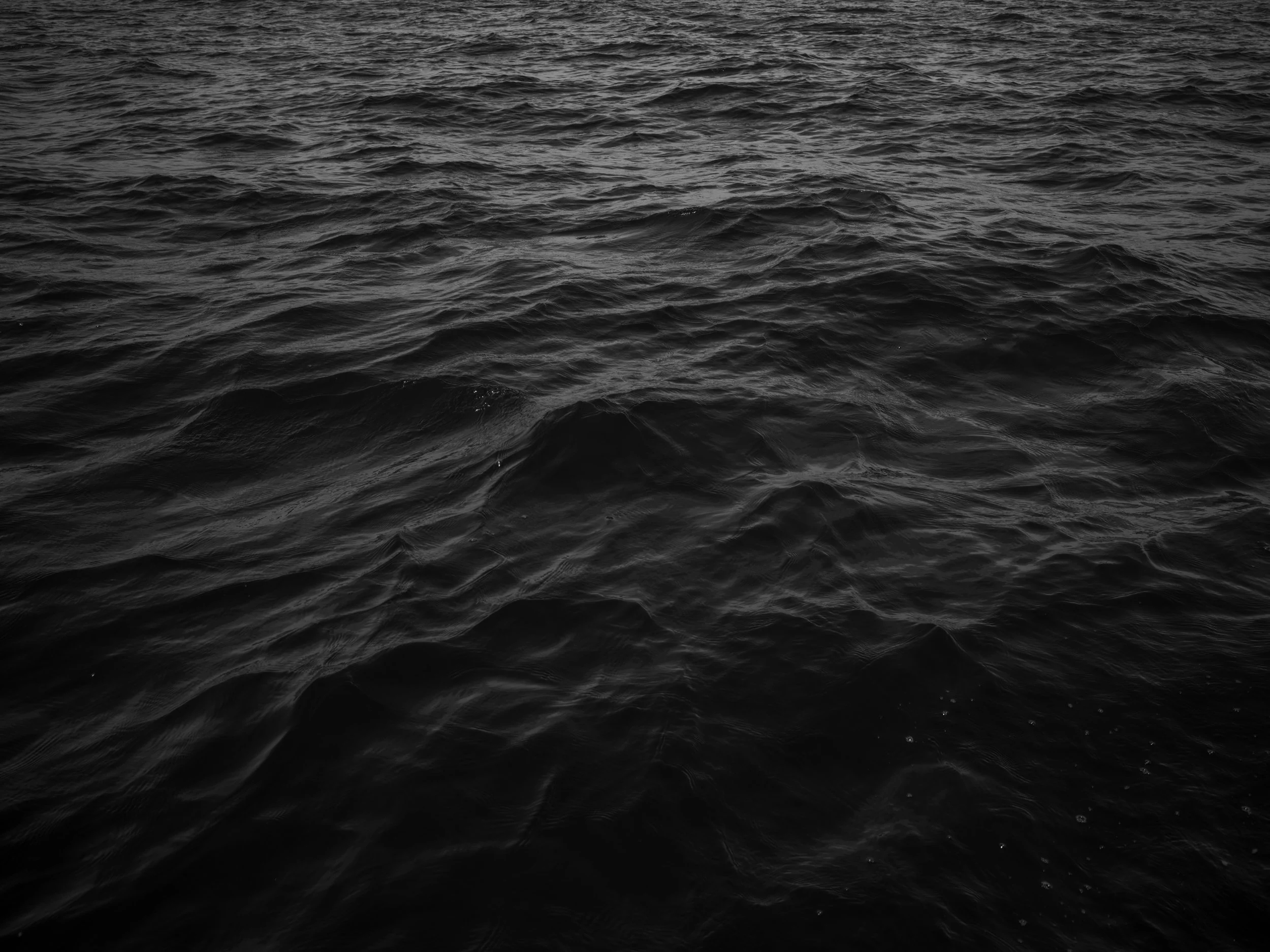 Dark ocean waves with no visible objects or land.