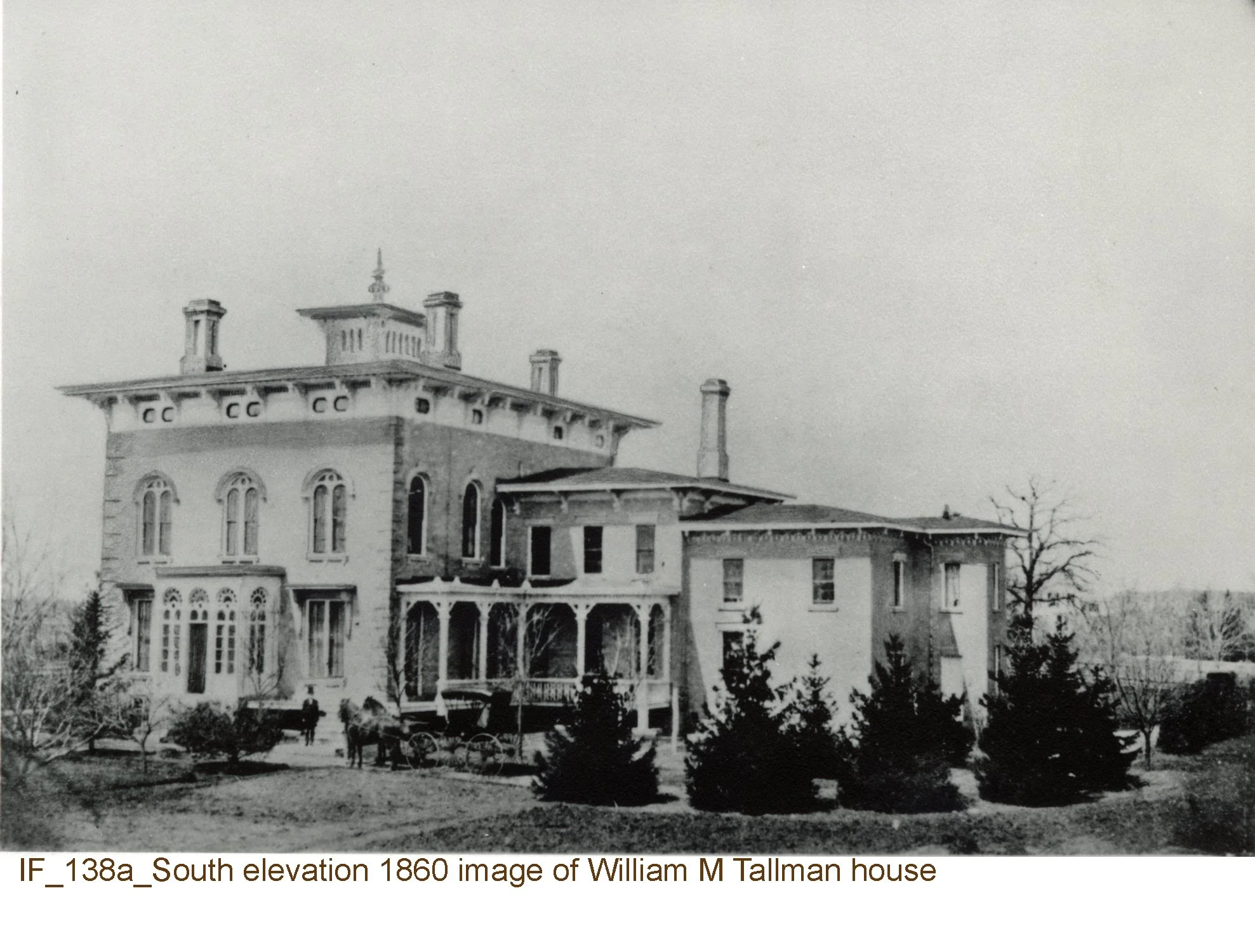 Black and white photograph of William M. Tallman house showing its south elevation with multiple stories, ornate windows, and towers, surrounded by trees and several people and horse-drawn carriages in the yard.